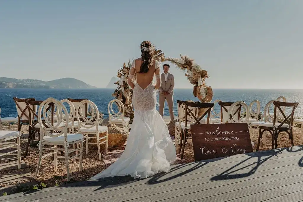 The bride walks to a pampas arch above the sea, 7Pines Ibiza