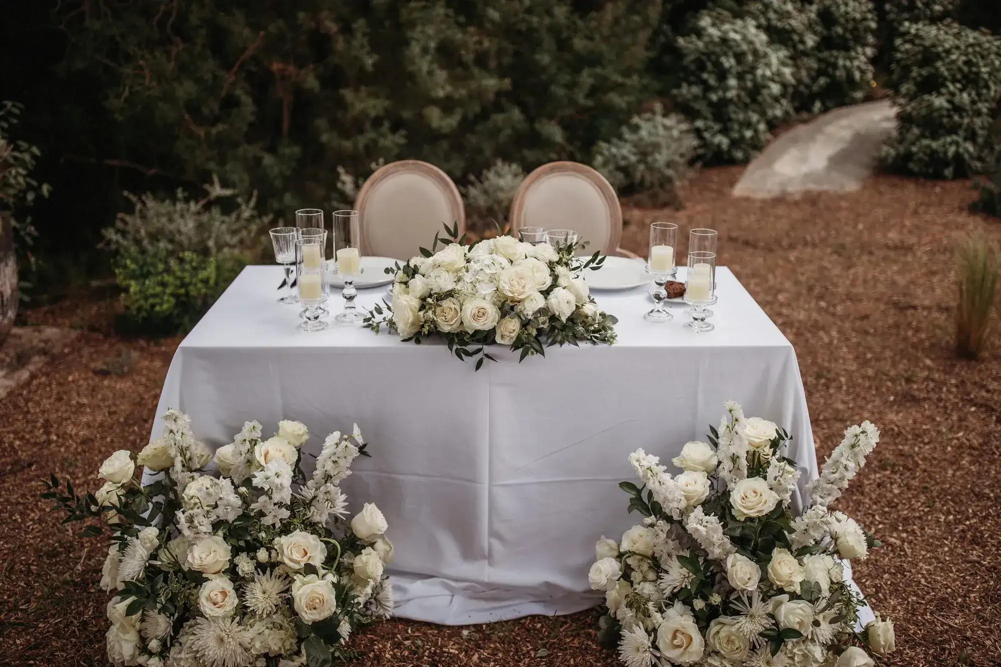 Sweetheart table banked with white roses