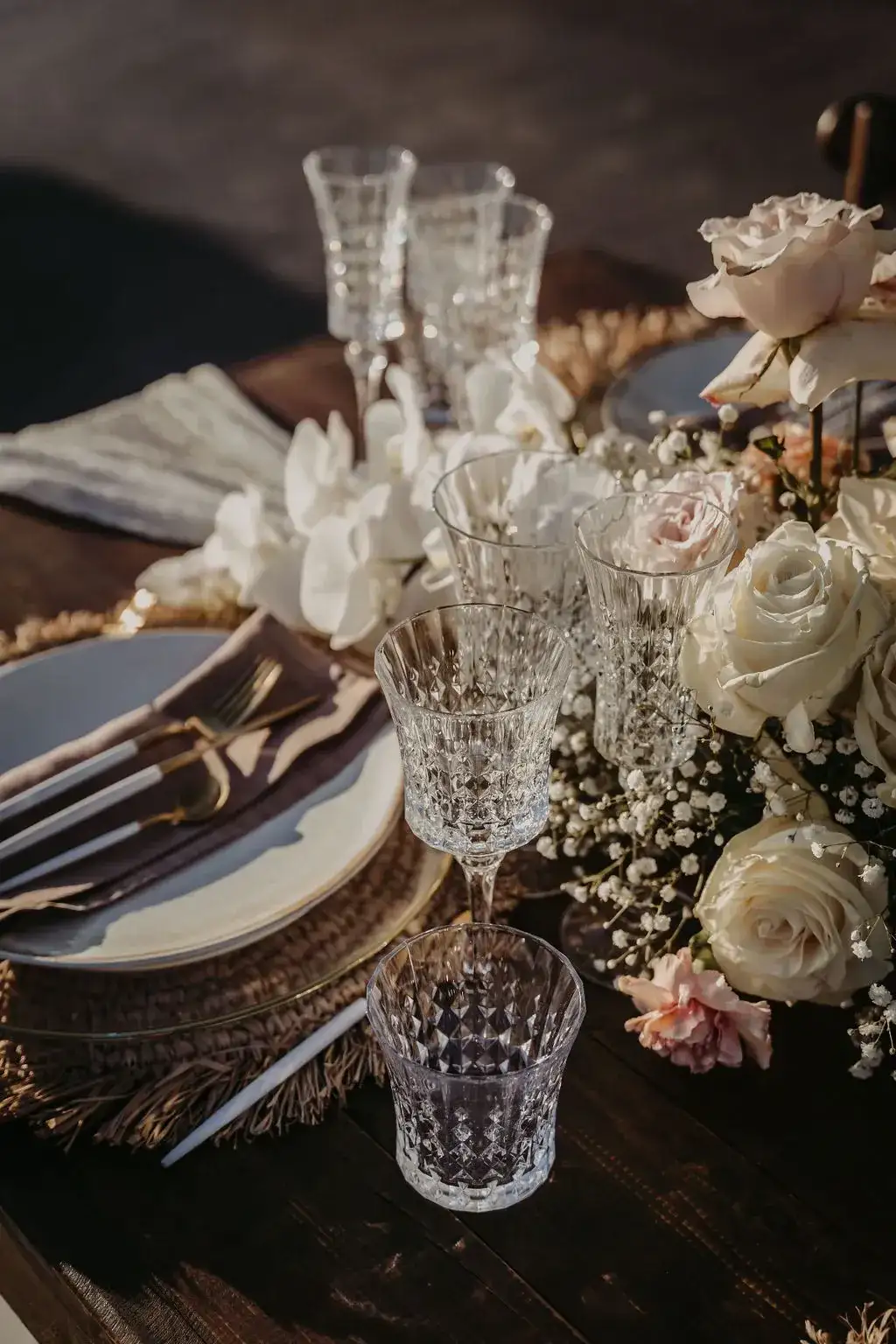 Crystal glasses and roses on a dark table, 7Pines Ibiza