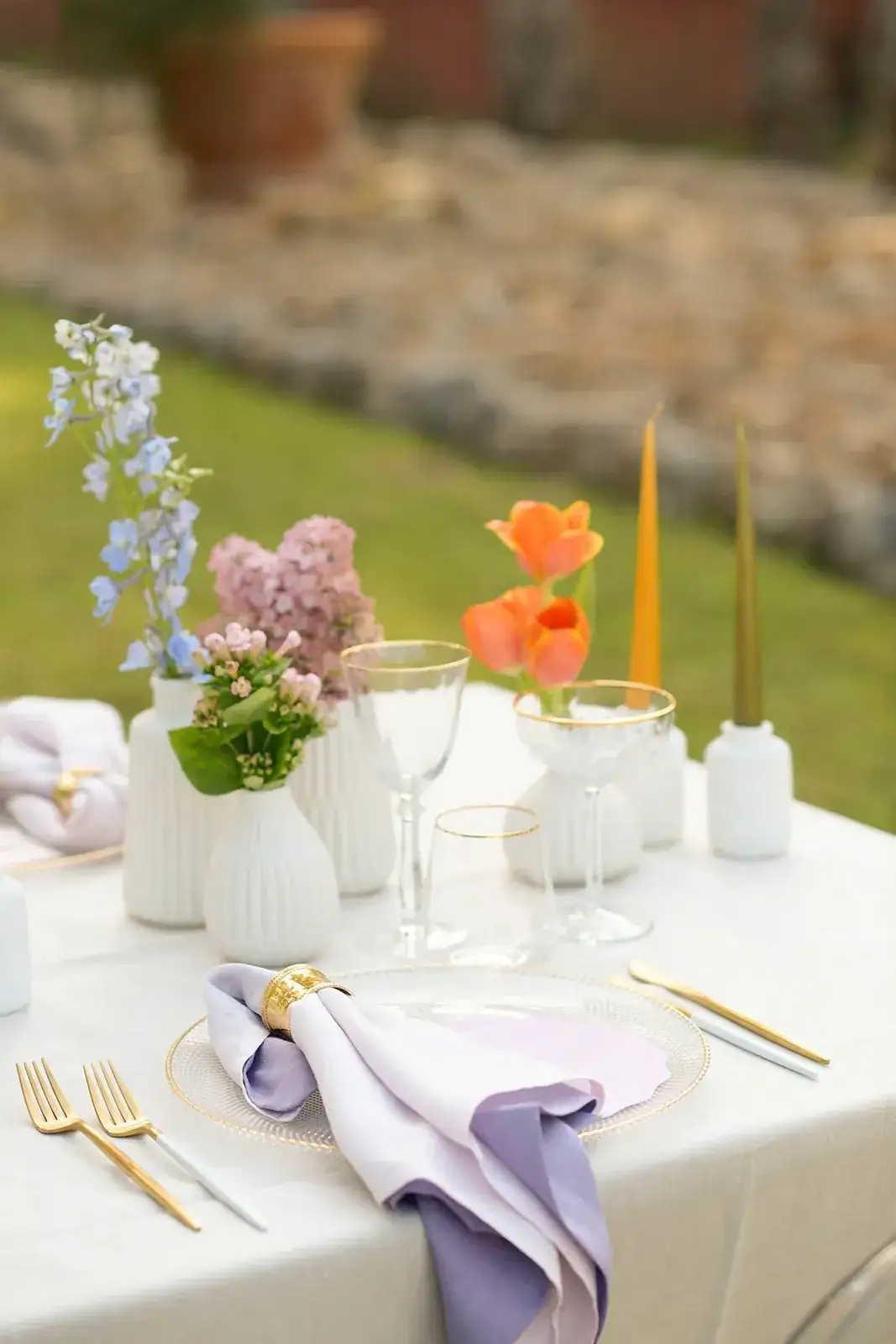 Orange poppies and pastel blooms on white linen, spring styled shoot