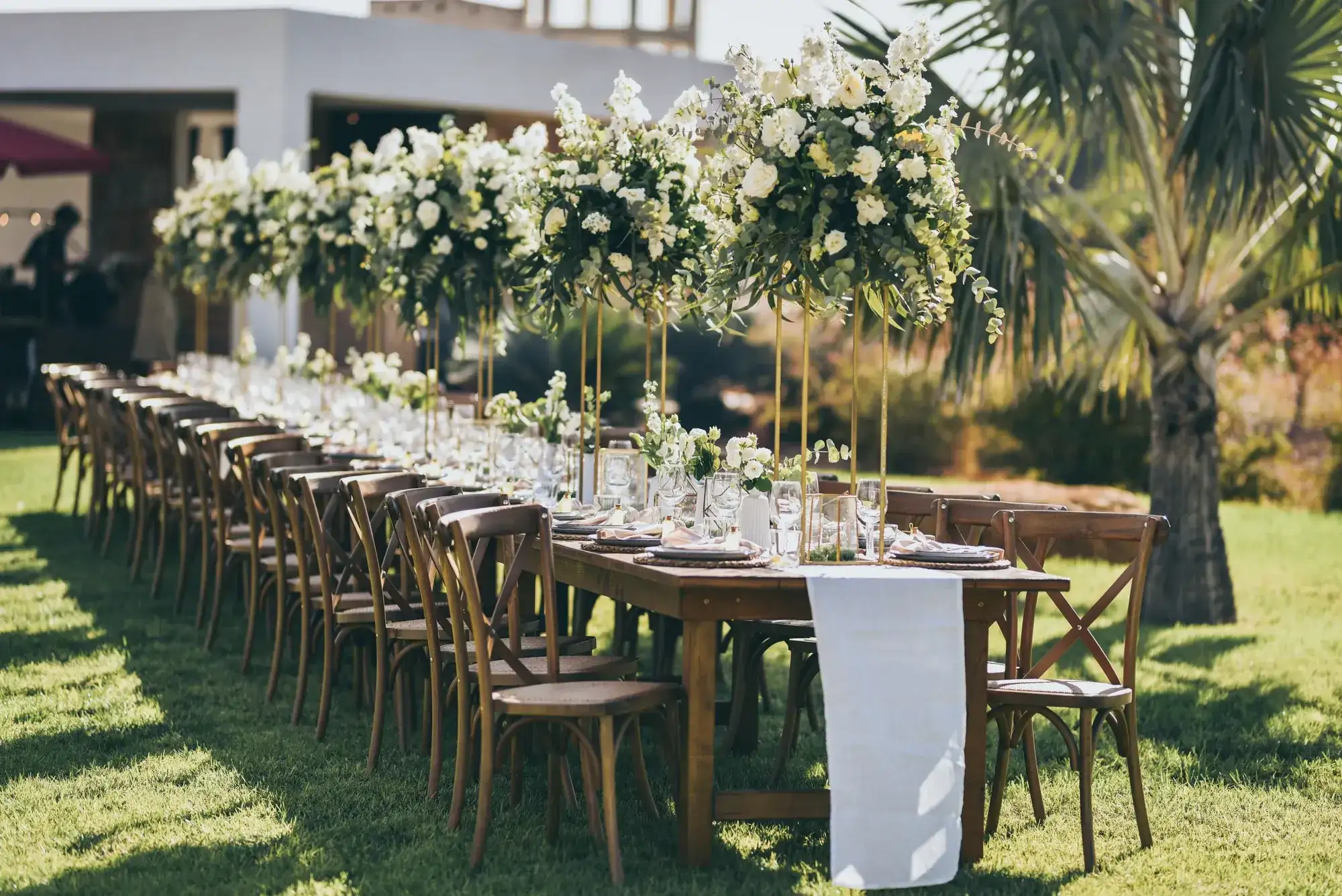 A row of white flower towers over long tables