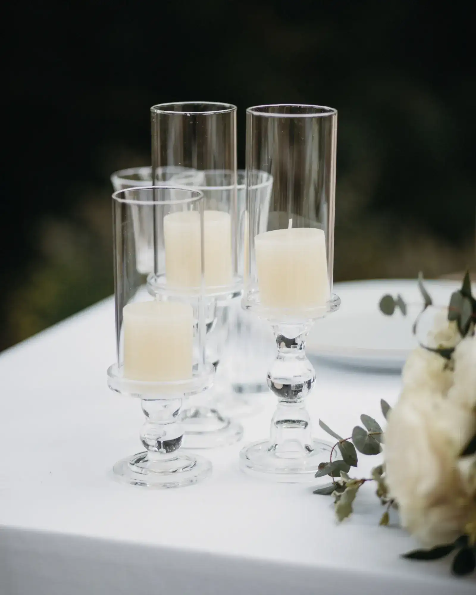 Pillar candles in glass hurricanes