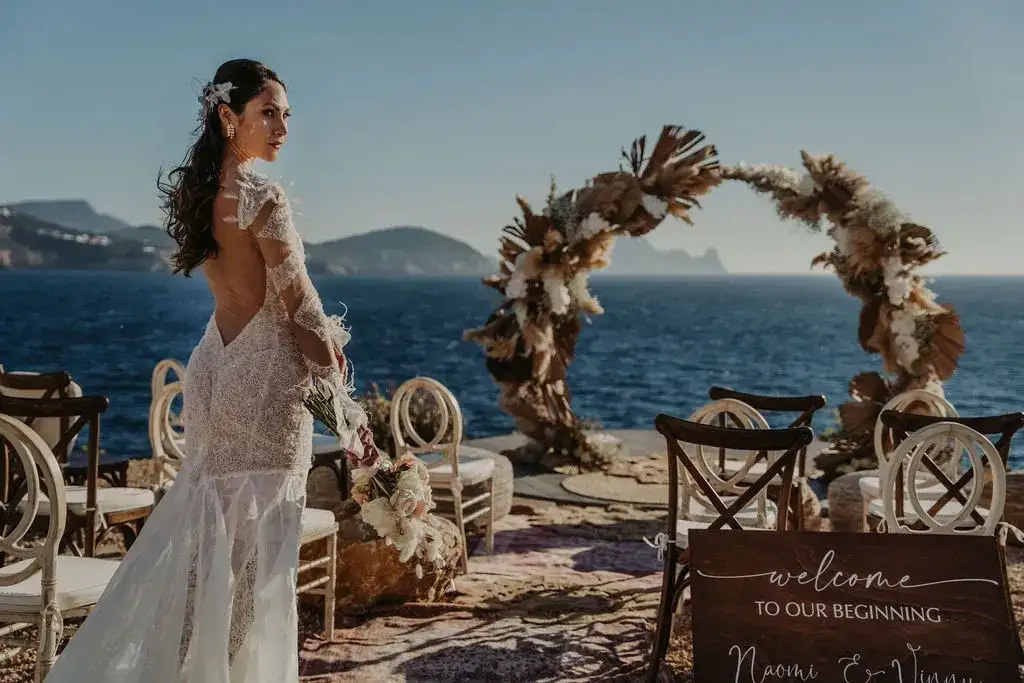Waiting at the pampas arch, sea and islands behind, 7Pines Ibiza