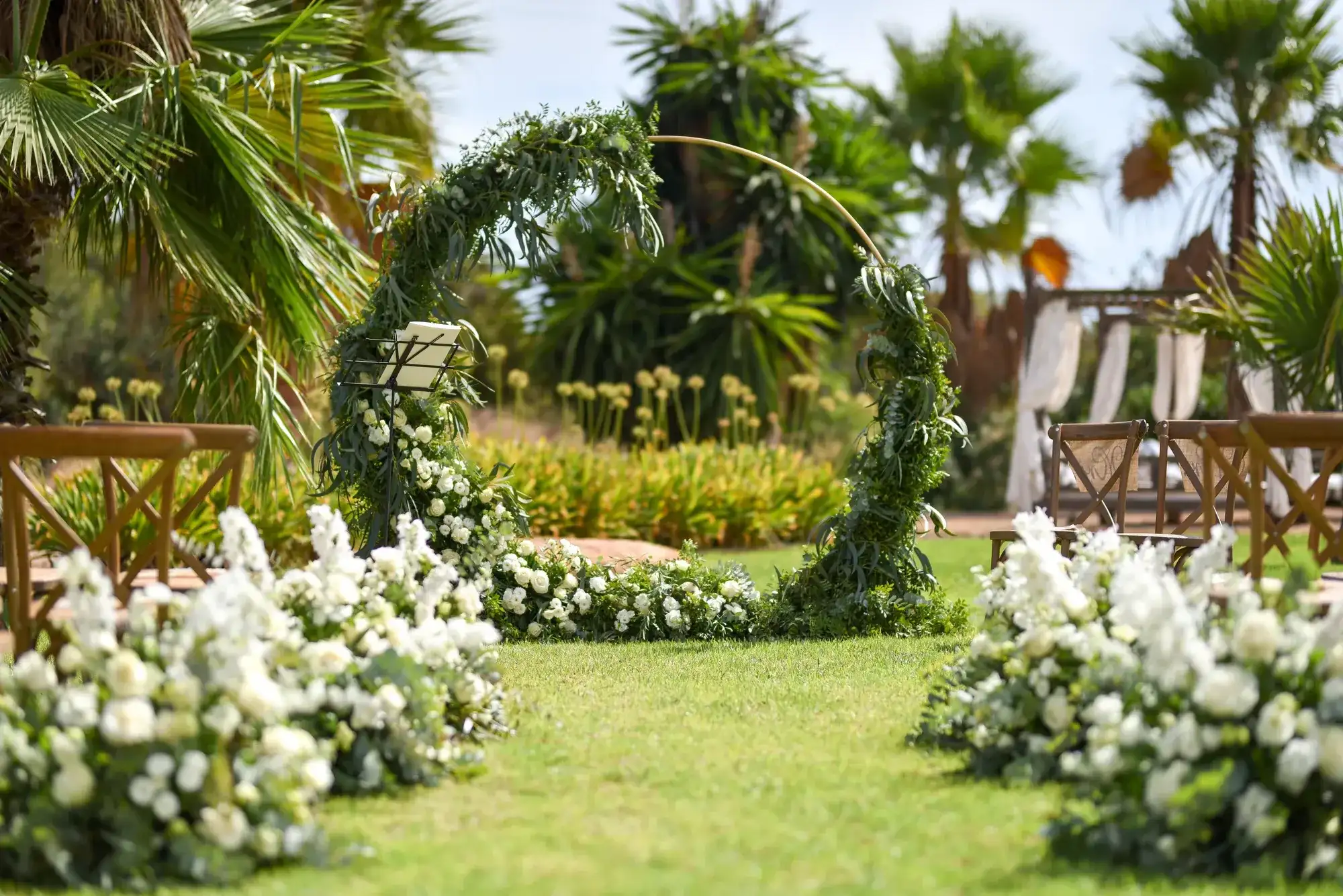 A hydrangea-lined aisle to a green hoop