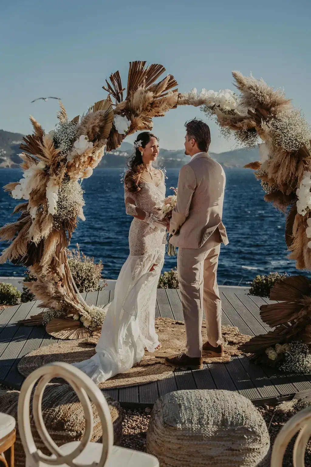 Vows under a dried-palm arch above the sea, 7Pines Ibiza