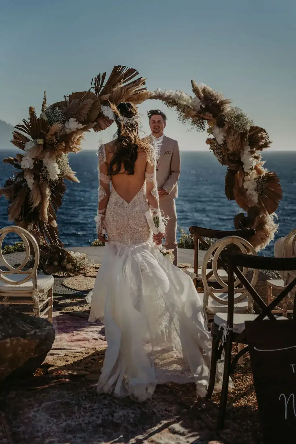 The bride at a dried-flower arch by the sea, 7Pines Ibiza