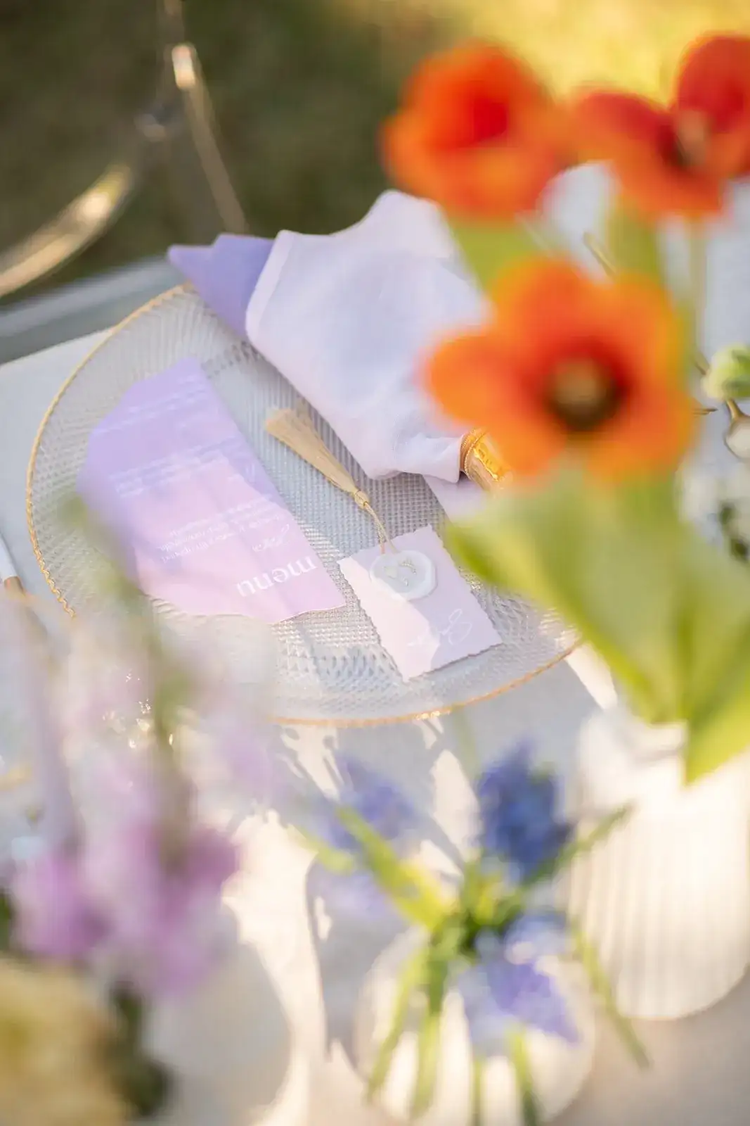 Orange poppies over a lilac place setting, spring styled shoot