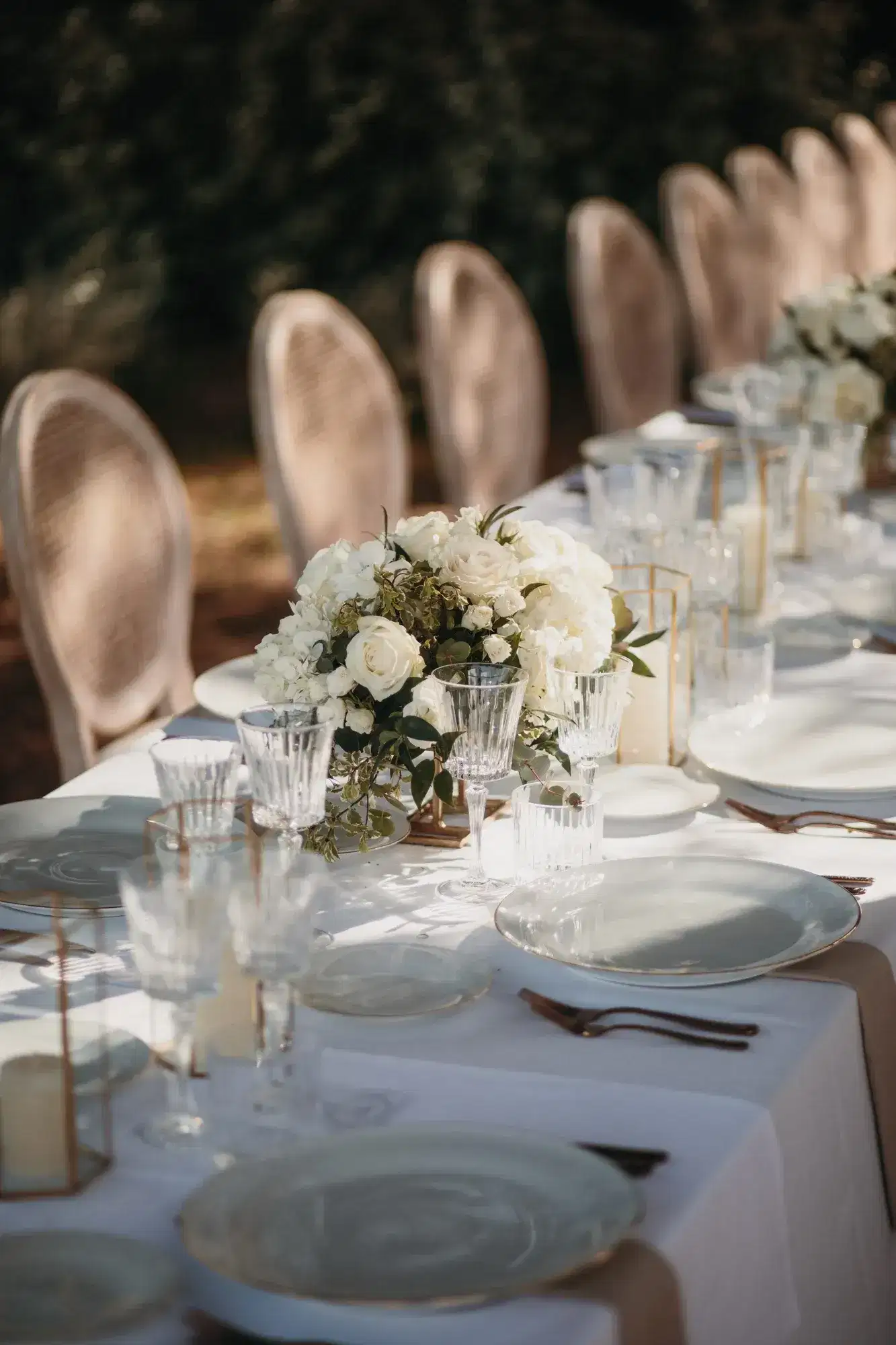 A long table with white roses and crystal