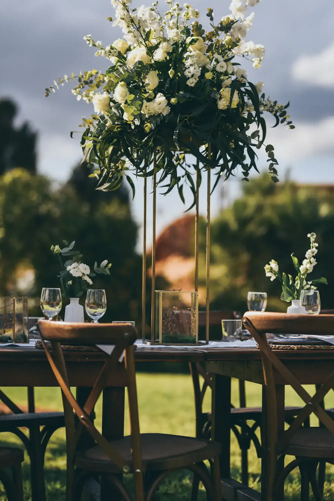 A tall arrangement of white flowers and greenery