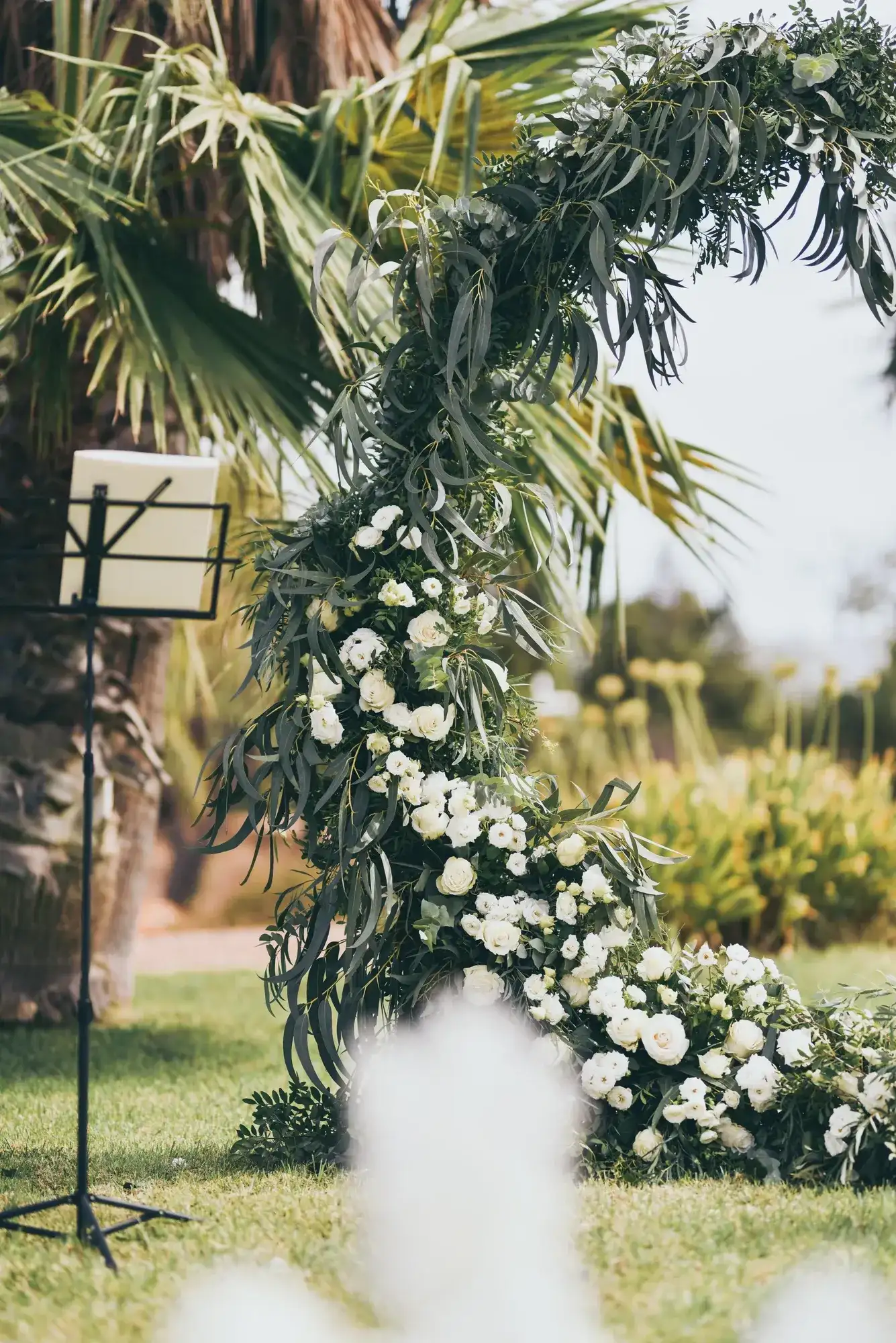A palm and white-flower ceremony arch