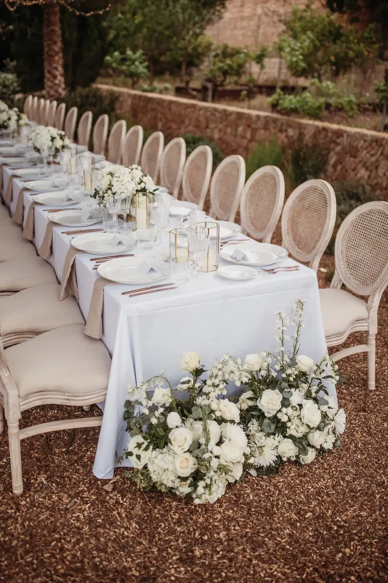 A long table with white rose arrangements