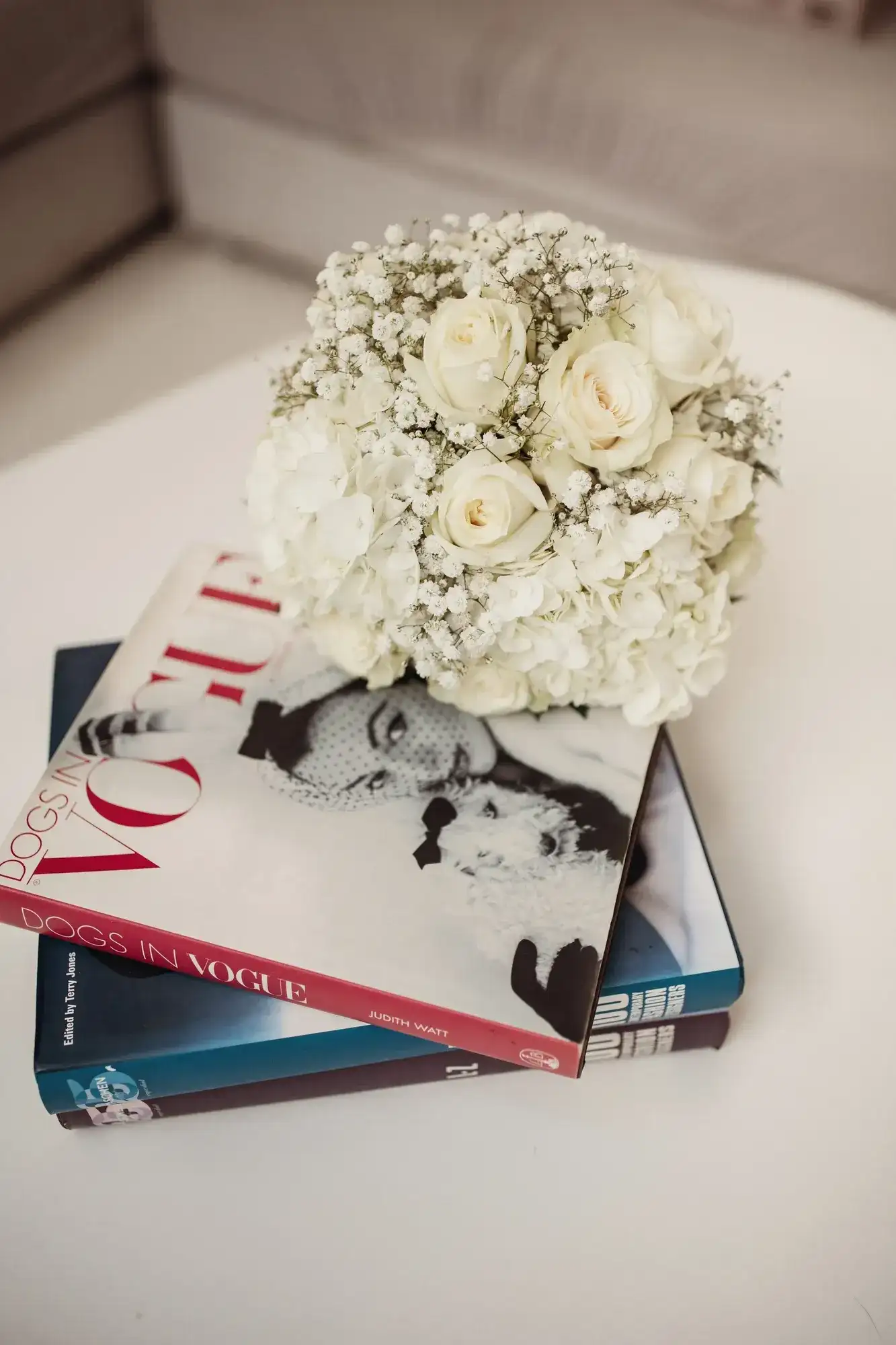 A white bouquet on a stack of fashion books