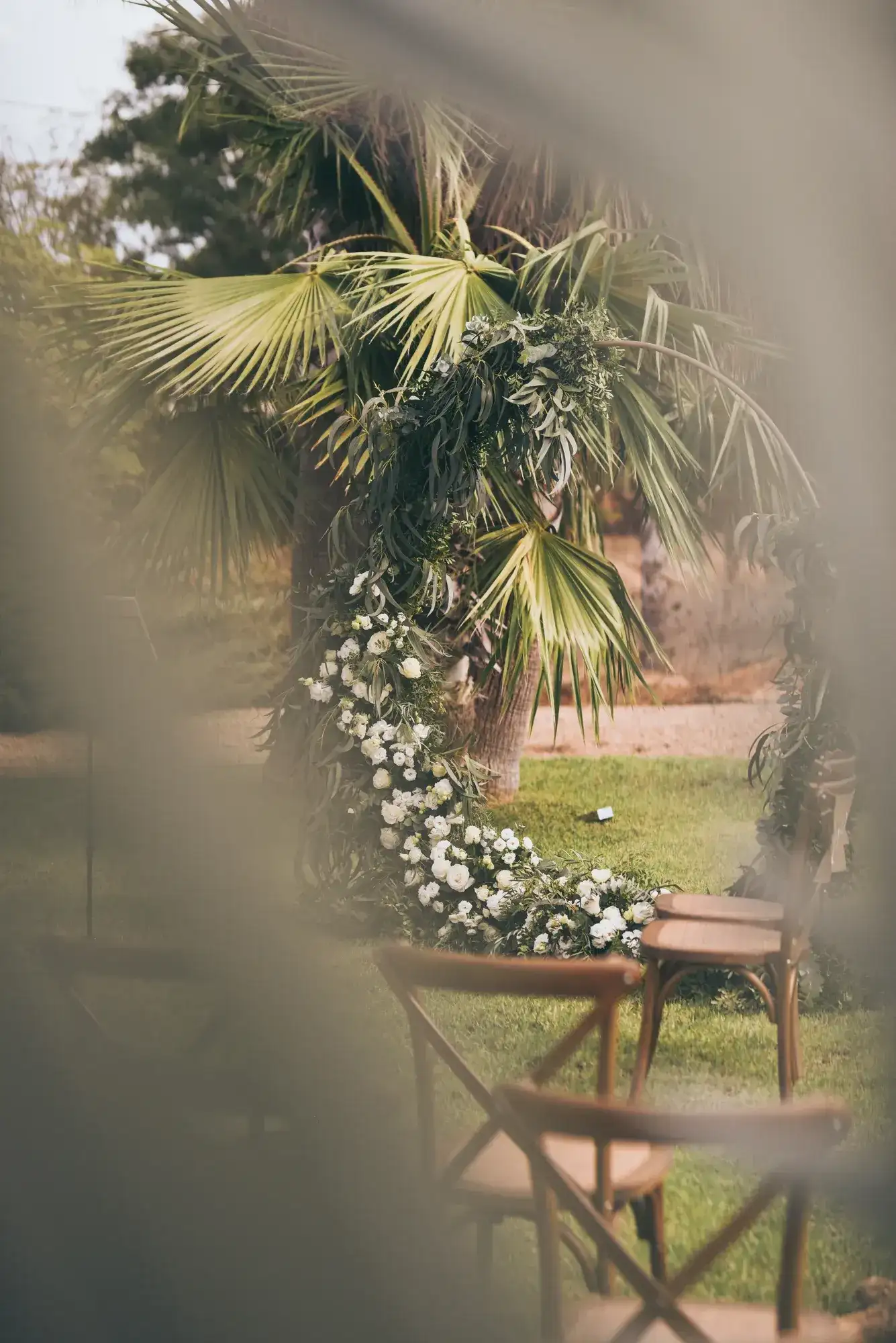 A floral arch glimpsed through the palms