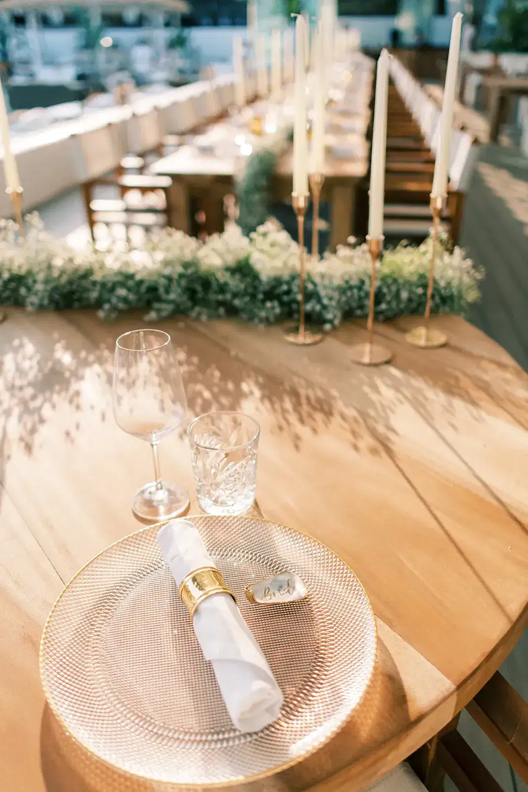 A glass plate and gold napkin ring on wood, Nikki Beach Ibiza