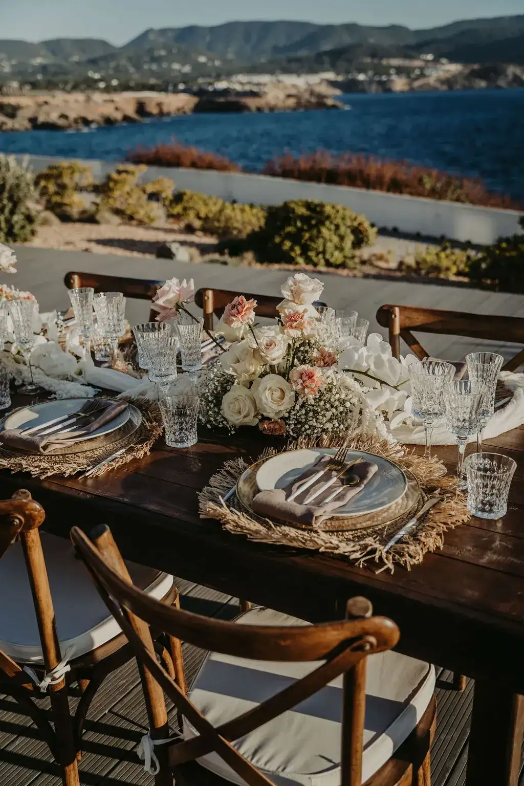 Rattan chargers and orchids, the sea below, 7Pines Ibiza