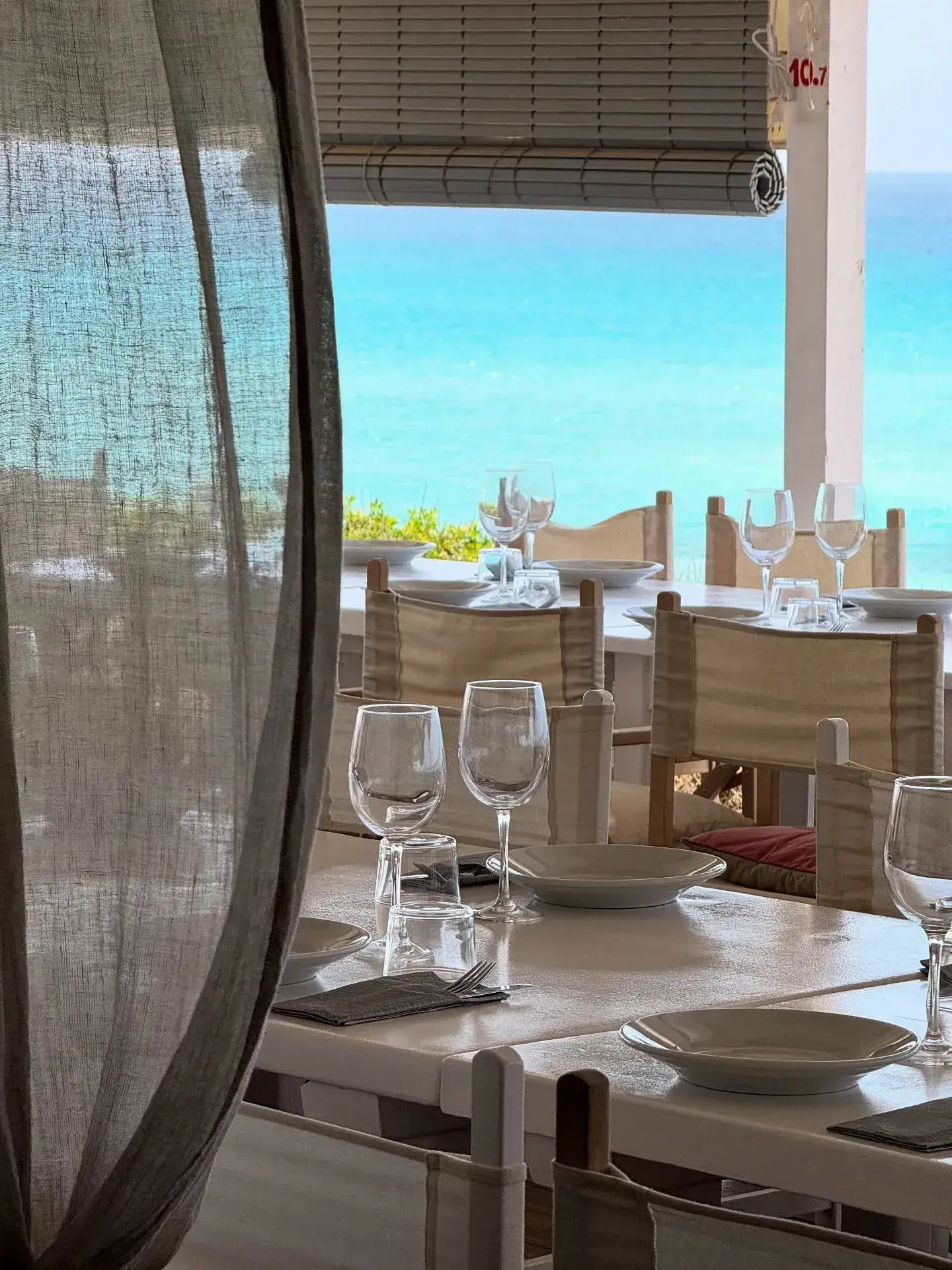 10.7 Formentera: Dining room with linen curtains and a turquoise sea view