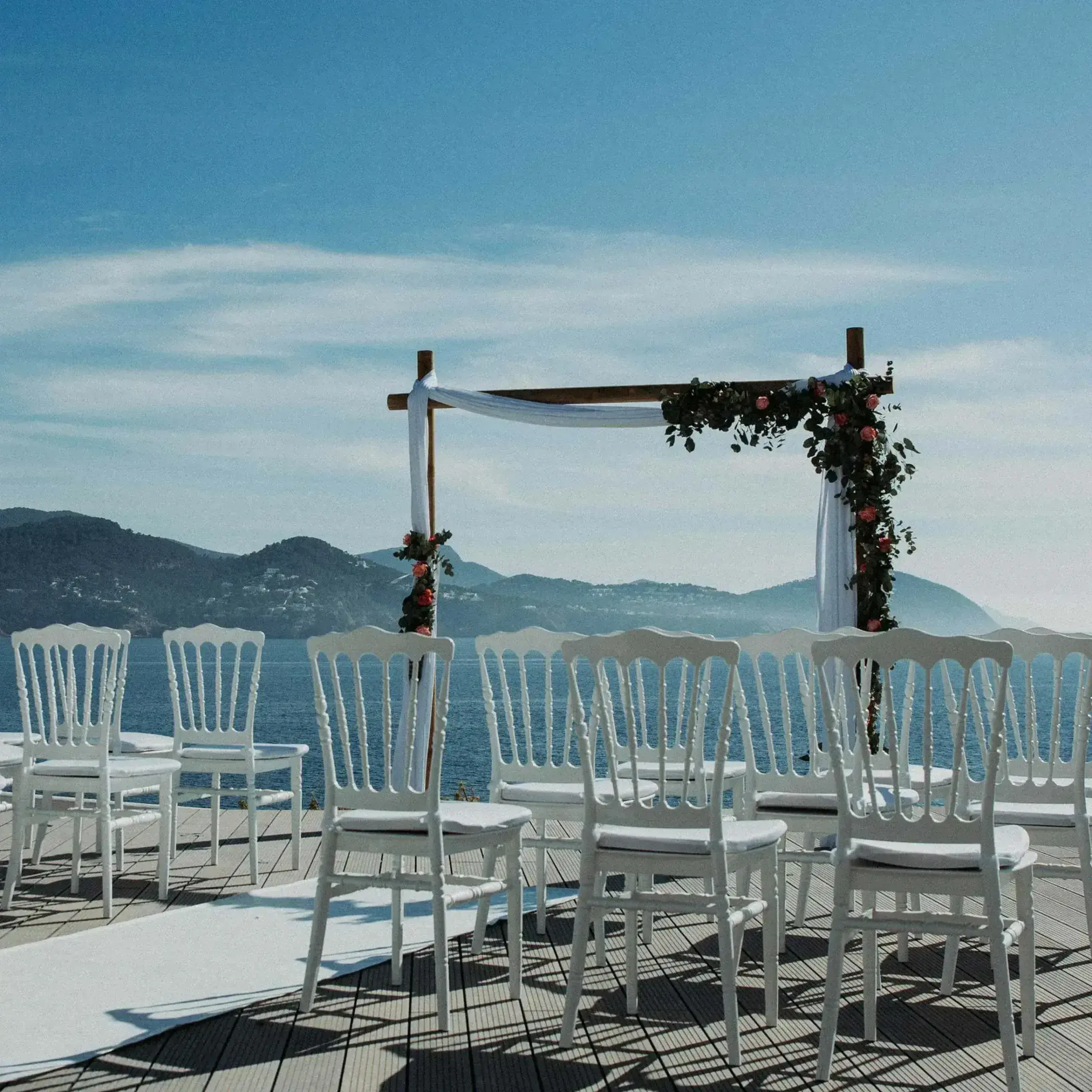 7Pines Resort Ibiza: Ceremony arch and white chairs on a terrace with sea and islands behind