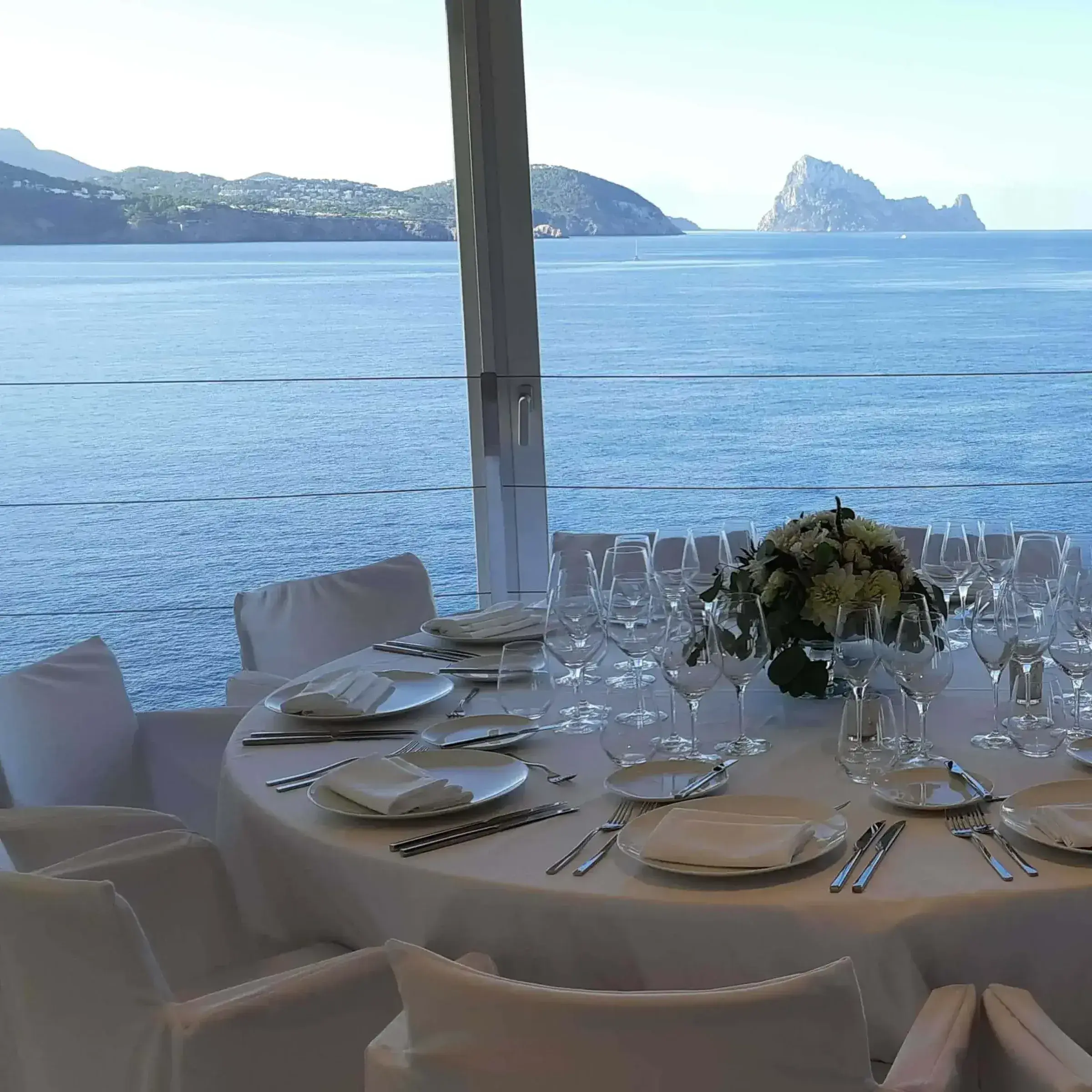 7Pines Resort Ibiza: Round dinner table set with Es Vedrà on the horizon