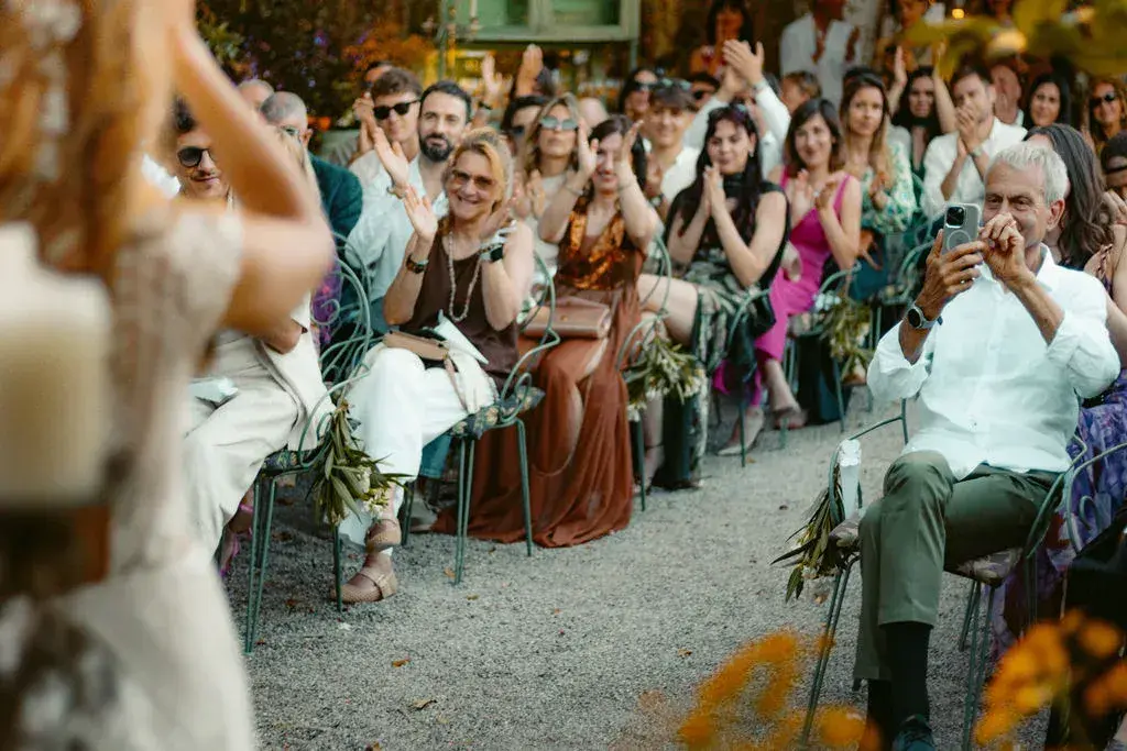 A mi Manera: Guests seated along a garden path during a ceremony