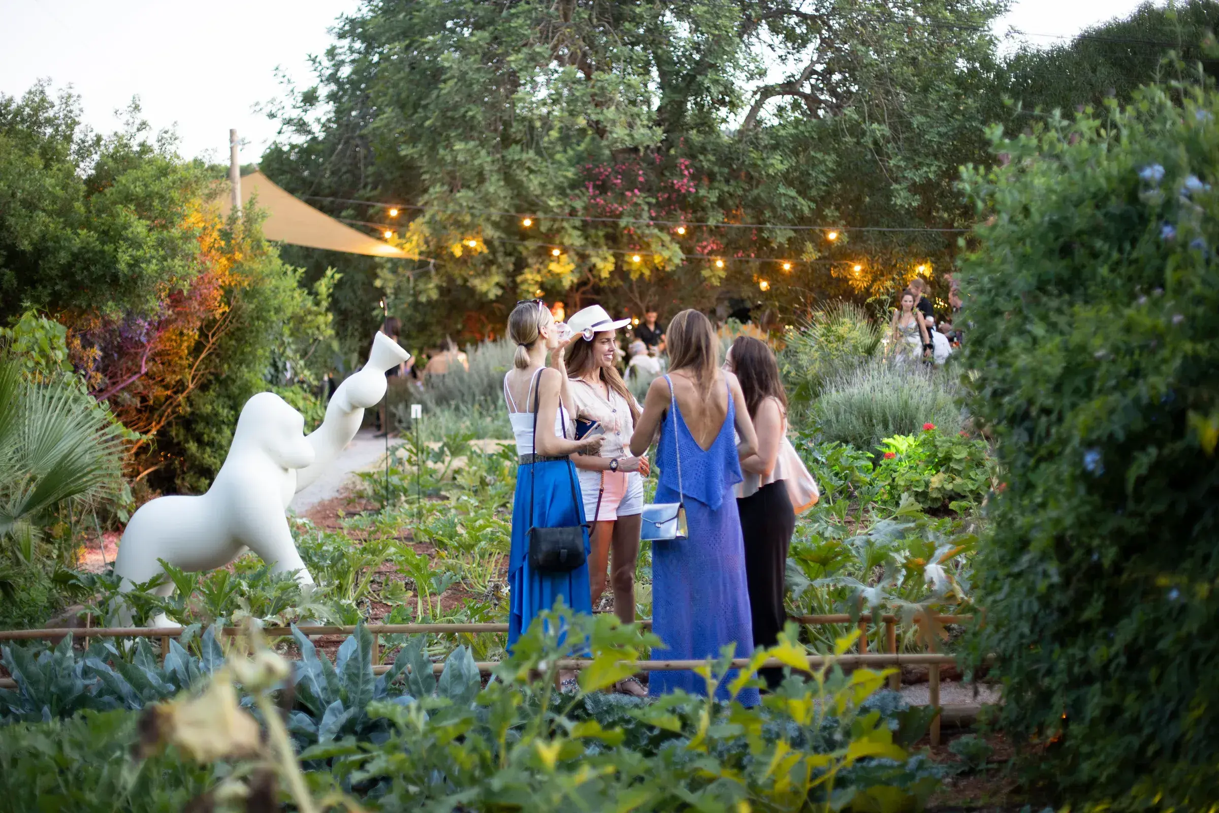 A mi Manera: Guests standing among the planted garden beds