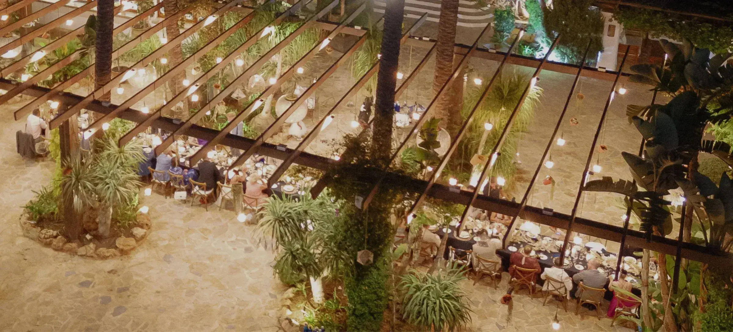 Agroturismo Atzaró: Wedding dinner tables laid out under a wooden pergola, seen from above