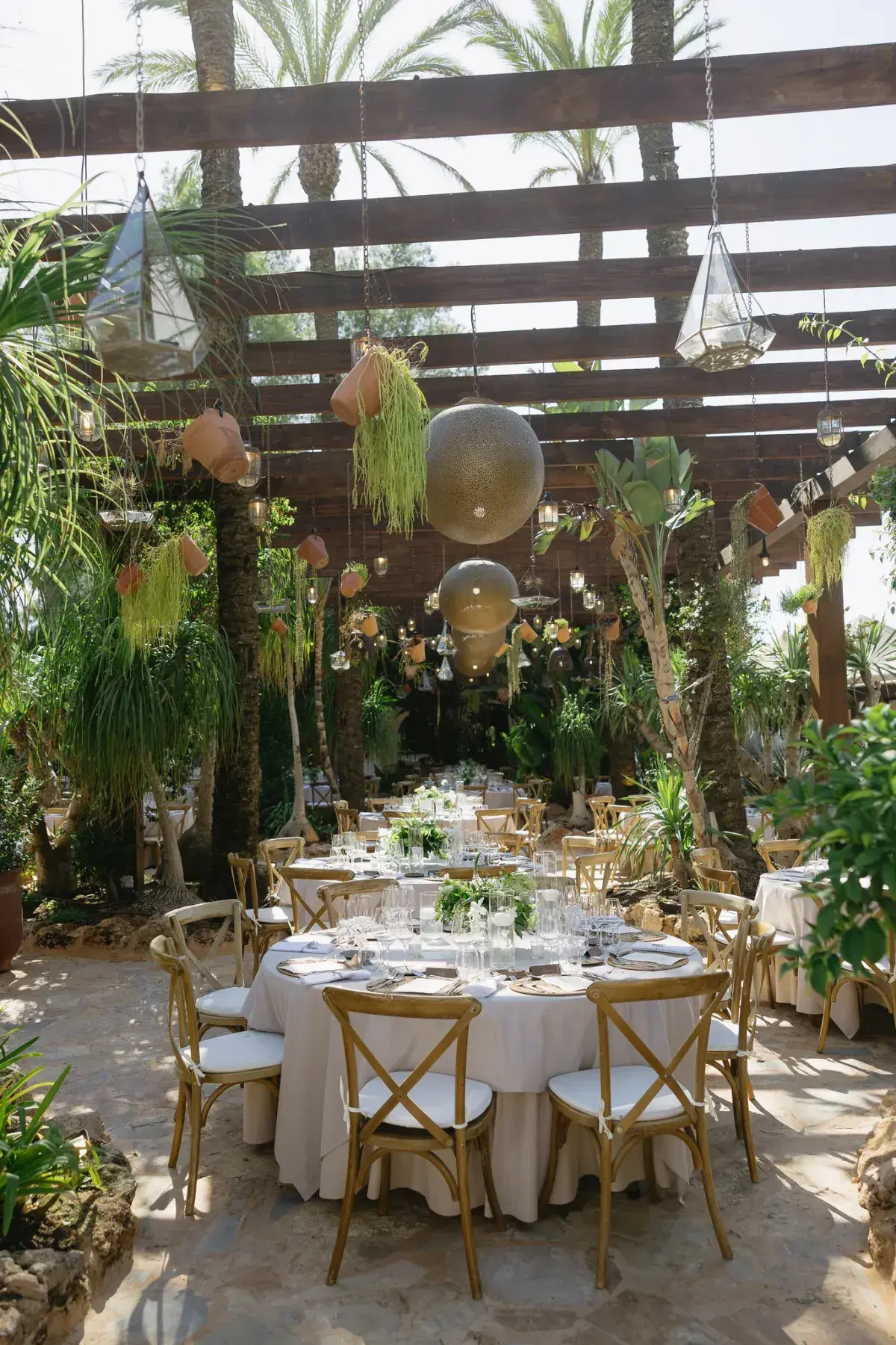 Wedding dinner tables under a pergola in the garden at Atzaró