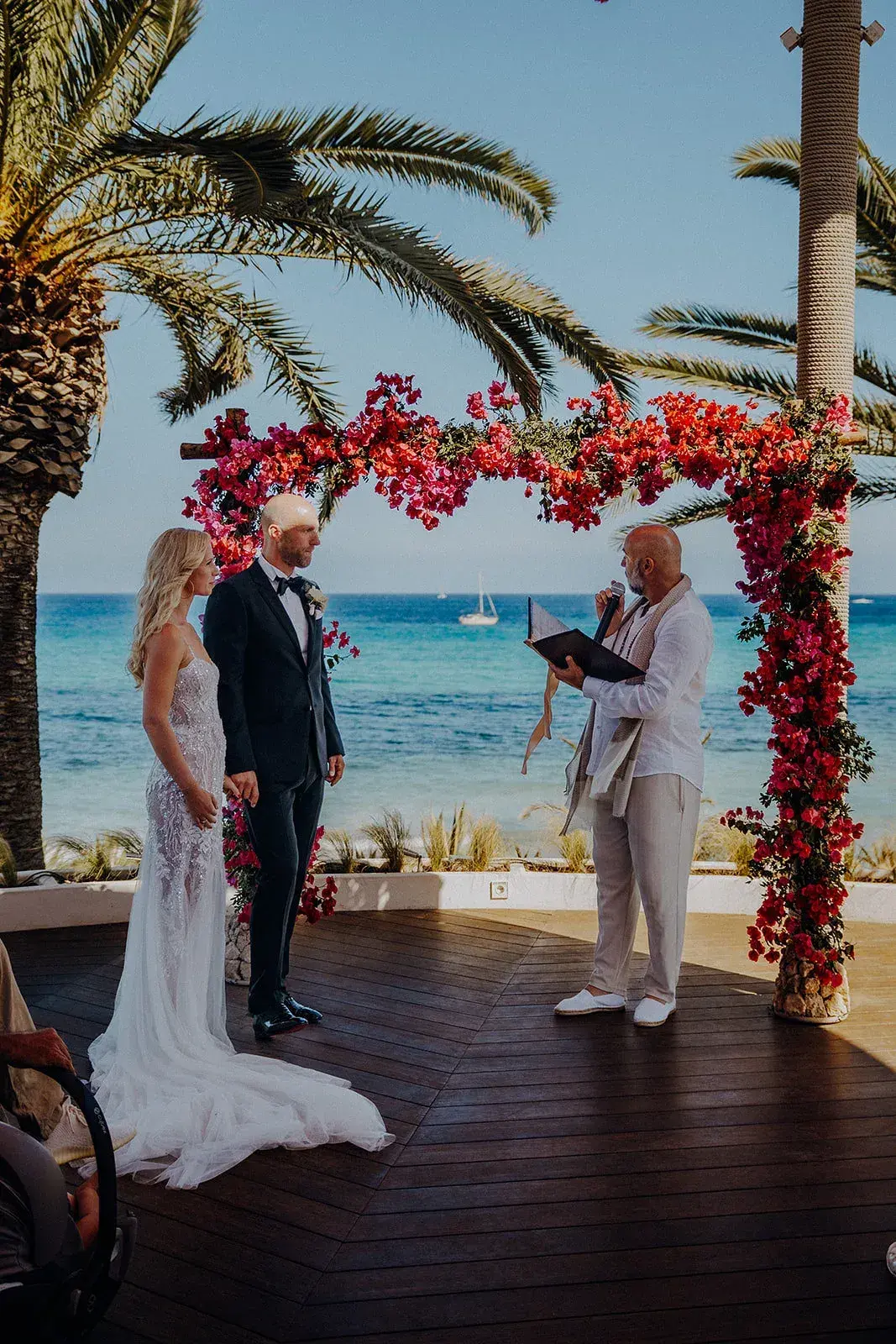 Aiyanna Ibiza: Couple at the altar under a bougainvillea arch during the ceremony