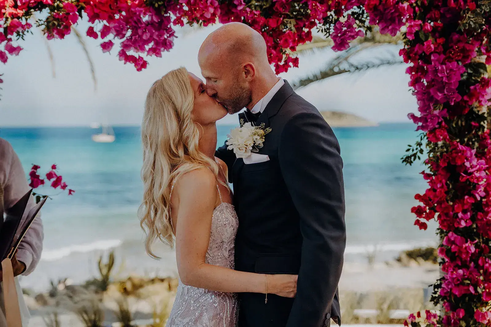 Aiyanna Ibiza: Couple kissing under the bougainvillea arch with Cala Nova behind