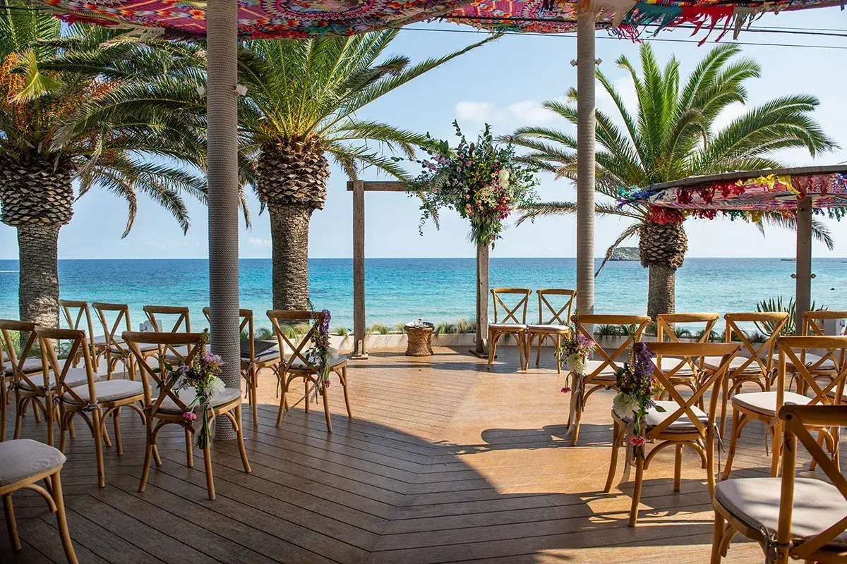 Aiyanna Ibiza: Ceremony chairs and flower arch on the terrace under colourful shade canopies