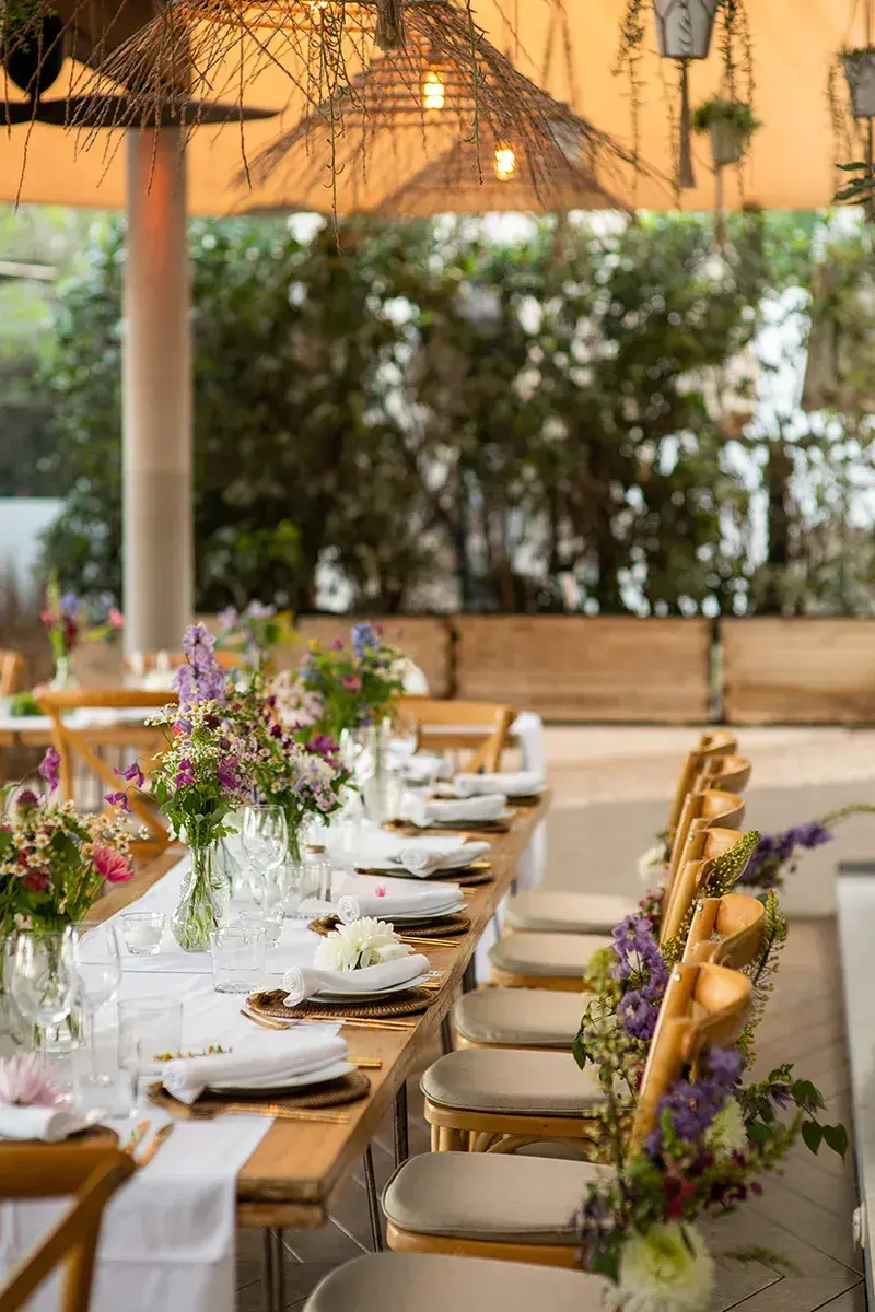 Aiyanna Ibiza: Long wedding dinner tables dressed with wildflowers under the covered terrace