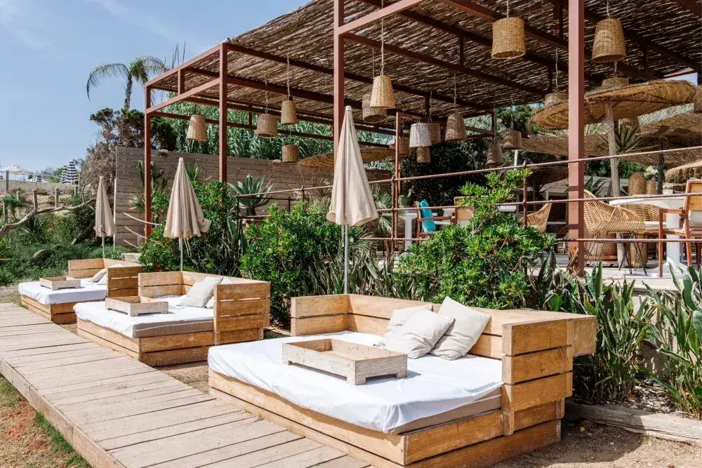 Atzaró Beach: Wooden daybeds on a boardwalk beside the pergola restaurant