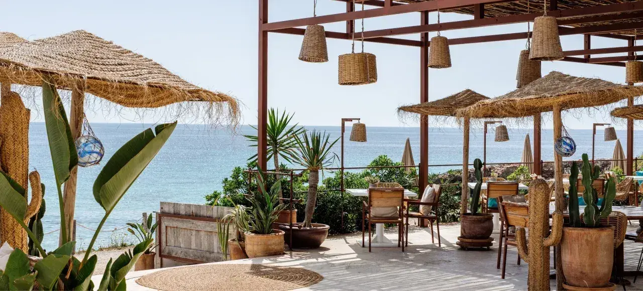 Atzaró Beach: Terrace dining under woven lamps and thatched parasols