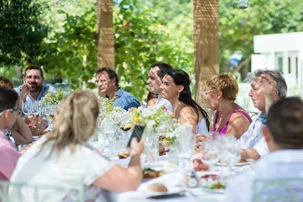 Aubergine by Atzaró: Guests eating at a long outdoor table in the garden