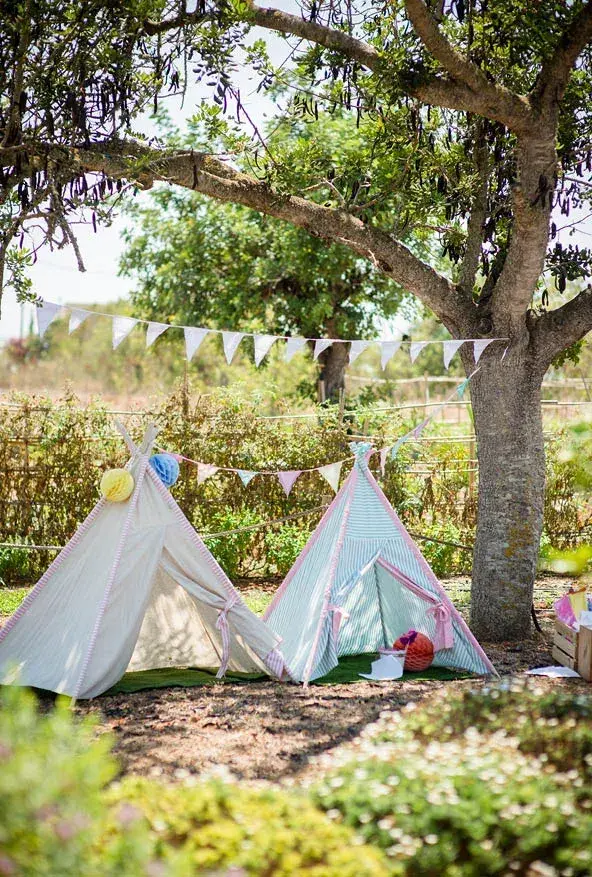 Aubergine by Atzaró: Small white tipis set up under trees for children