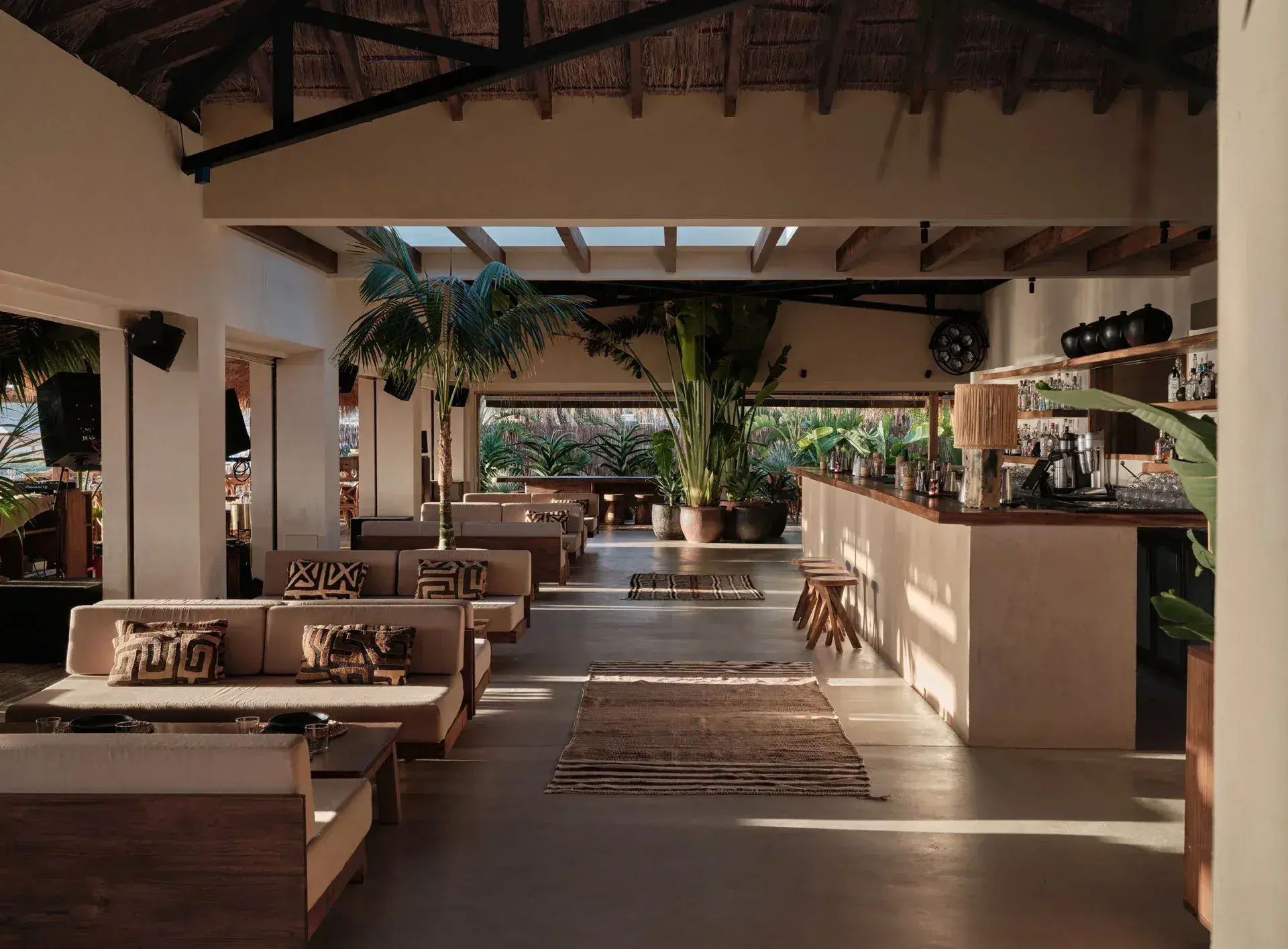 Beachouse Ibiza: Open-air lounge and bar with sofas, rugs and palms