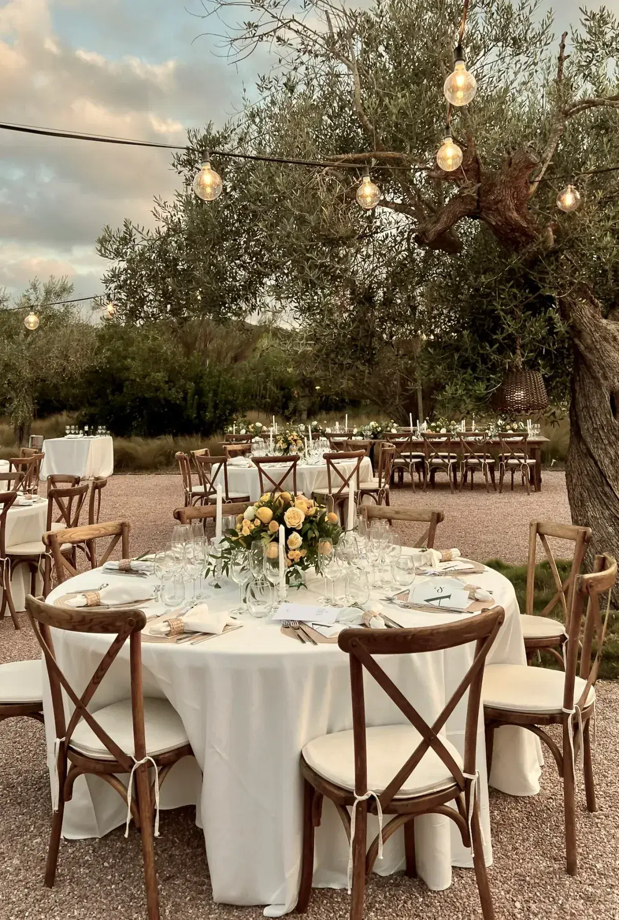 Wedding dinner table under the trees in the garden at Ca Na Xica