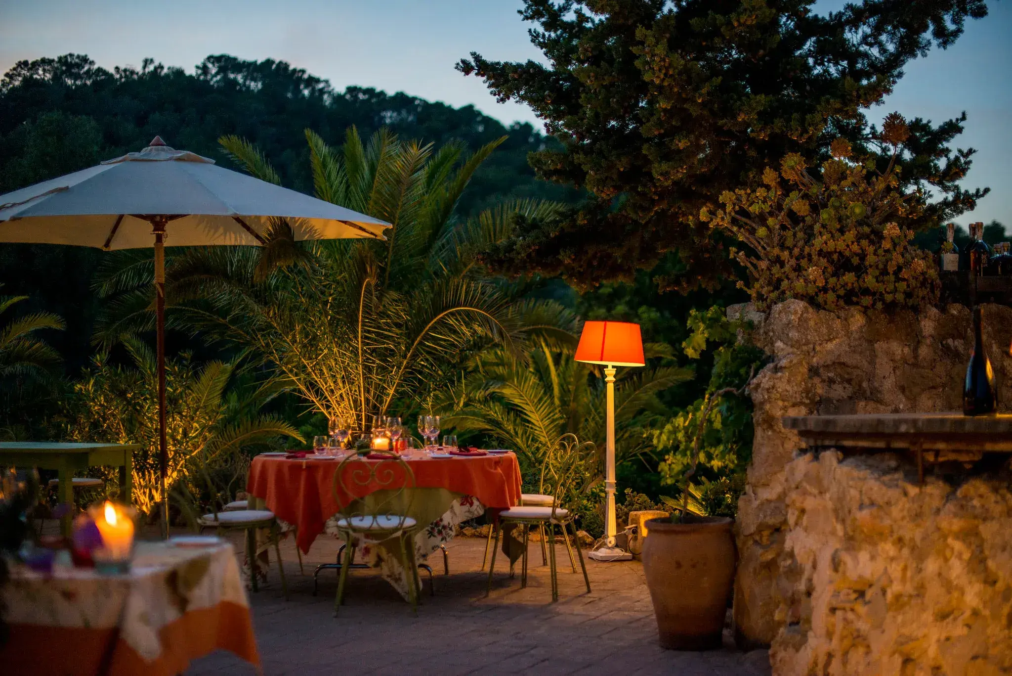 Can Domingo: Garden terrace with lamps and set tables at dusk