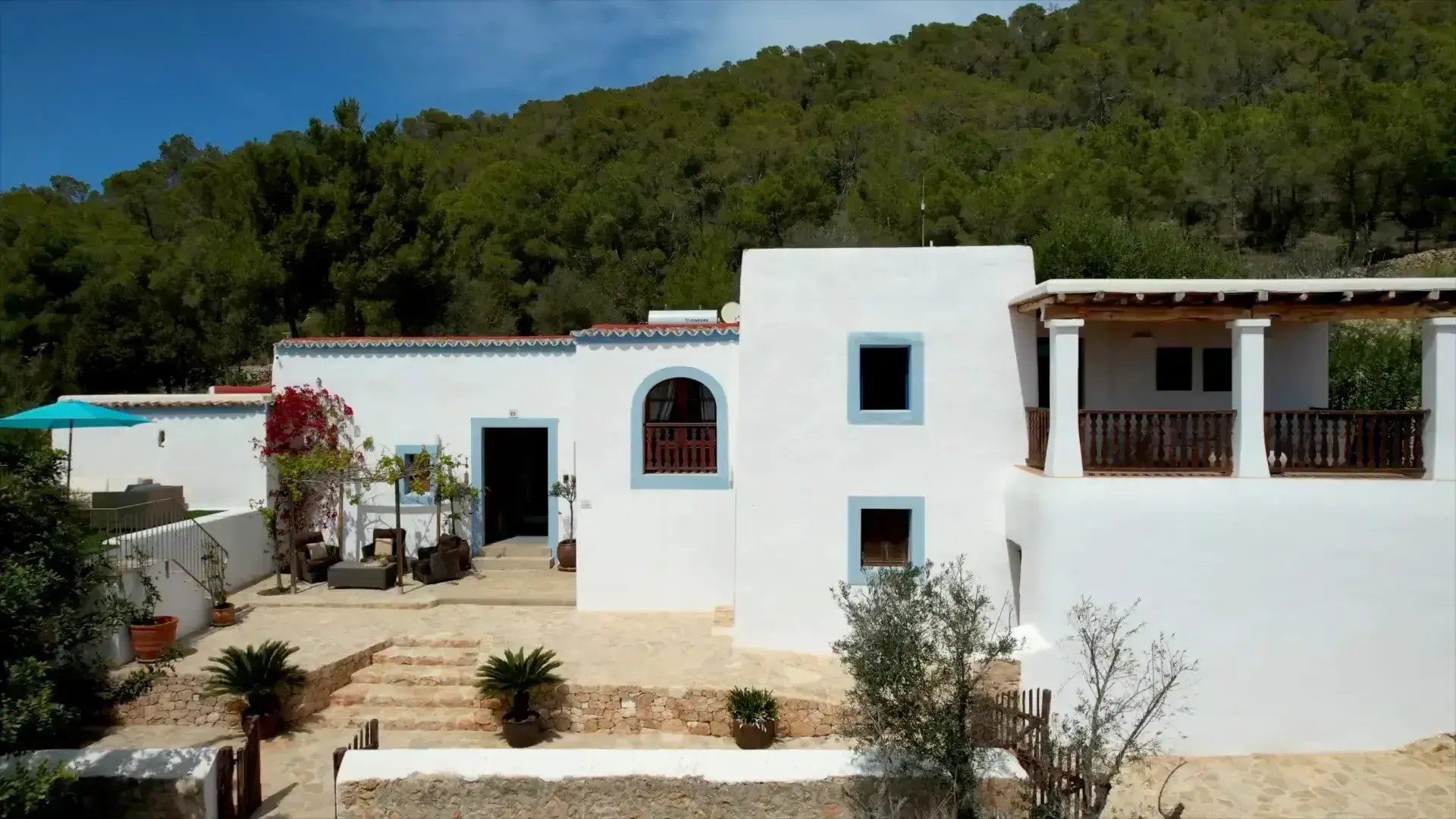 Can Frare: Whitewashed farmhouse facade with blue window frames