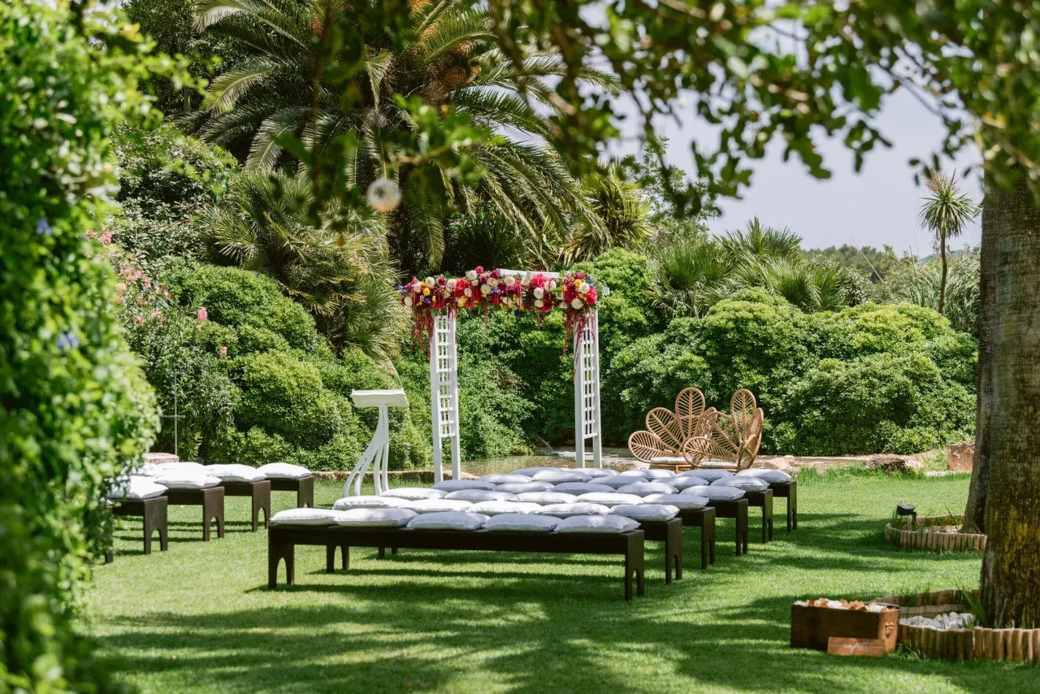 Can Gall: Ceremony set-up on the lawn with benches and a flower arch