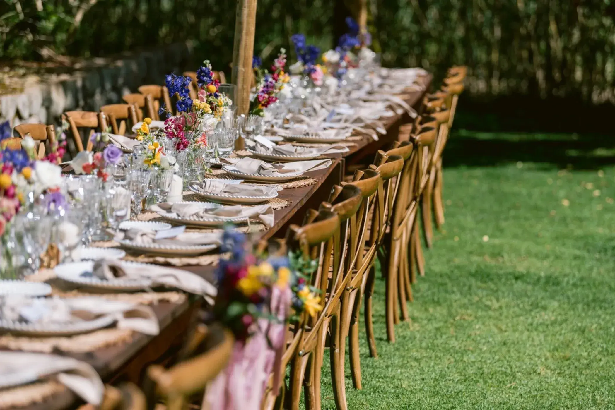 Can Gall: Long wedding table with colourful flowers on the grass