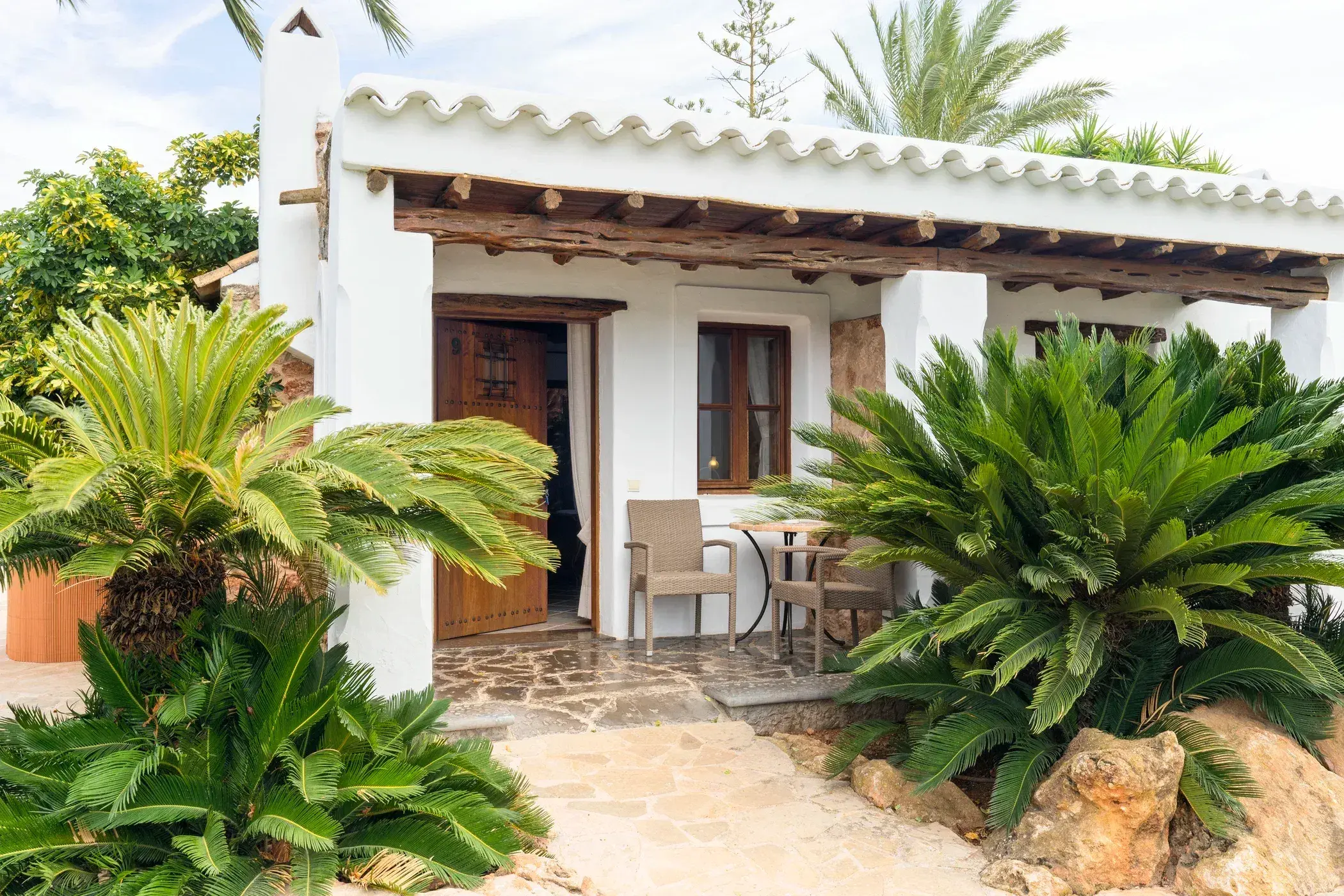 Can Gall: Whitewashed guest house with timber porch and cycad palms
