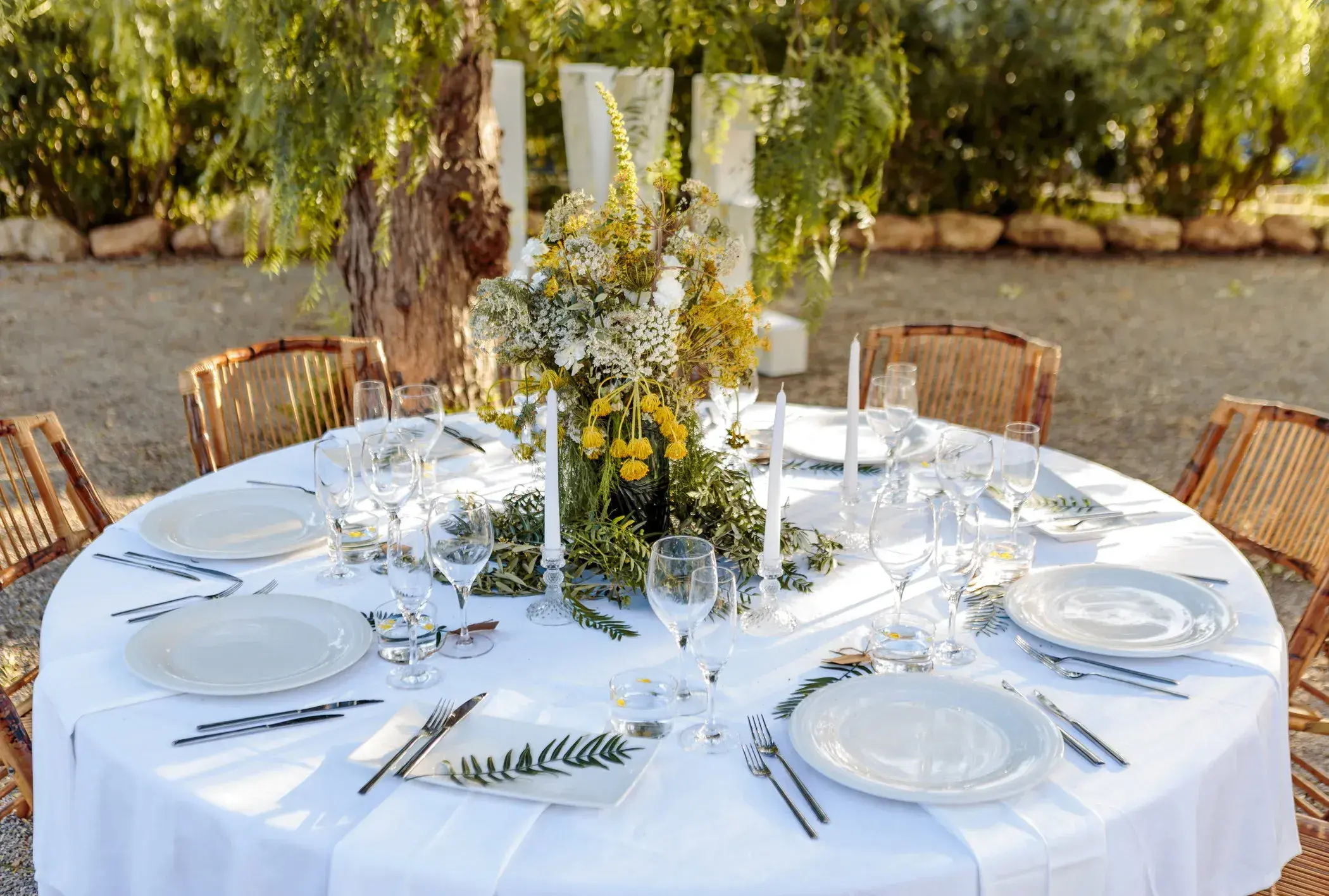 Can Lluc: Round dinner table with white linen and wildflower centrepiece in the garden