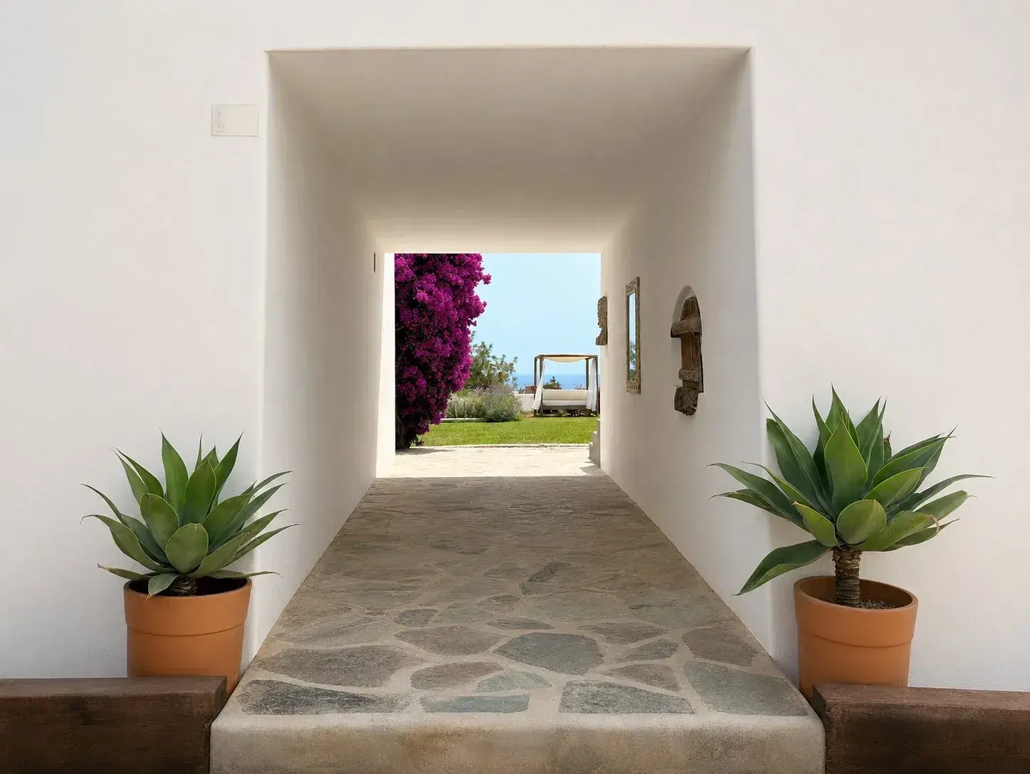 Can Skye Ibiza: Whitewashed passage with stone floor and potted agaves
