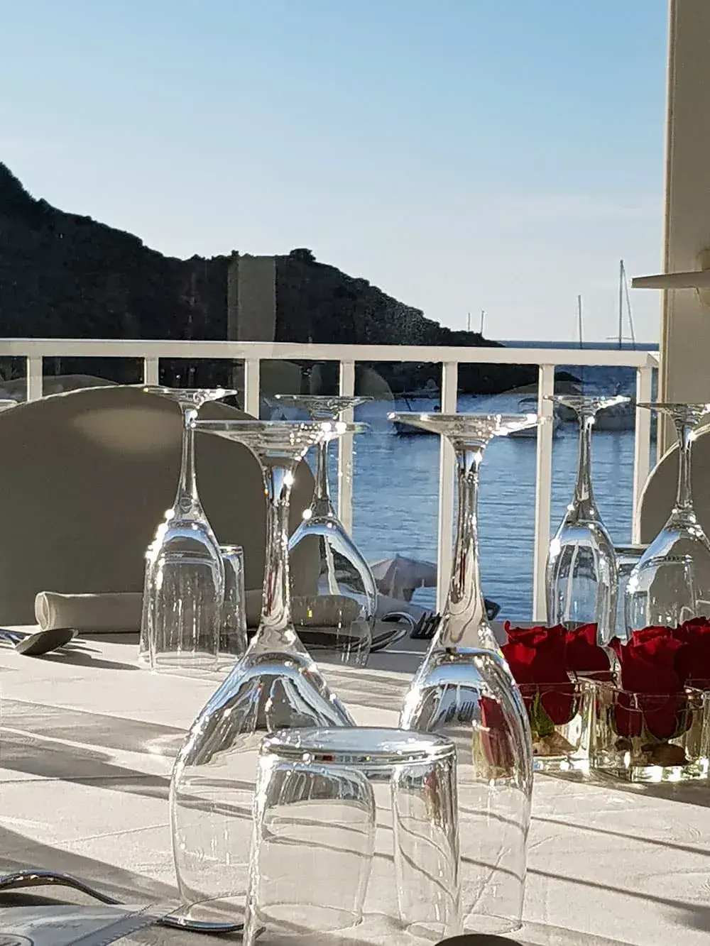 Cana Sofía: Table glasses and red roses on the terrace overlooking the bay