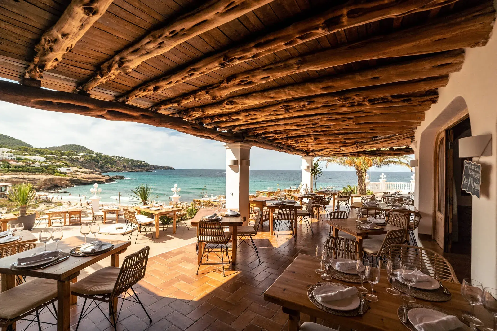 Cas Milà: Covered terrace with a wooden-beam roof above the beach