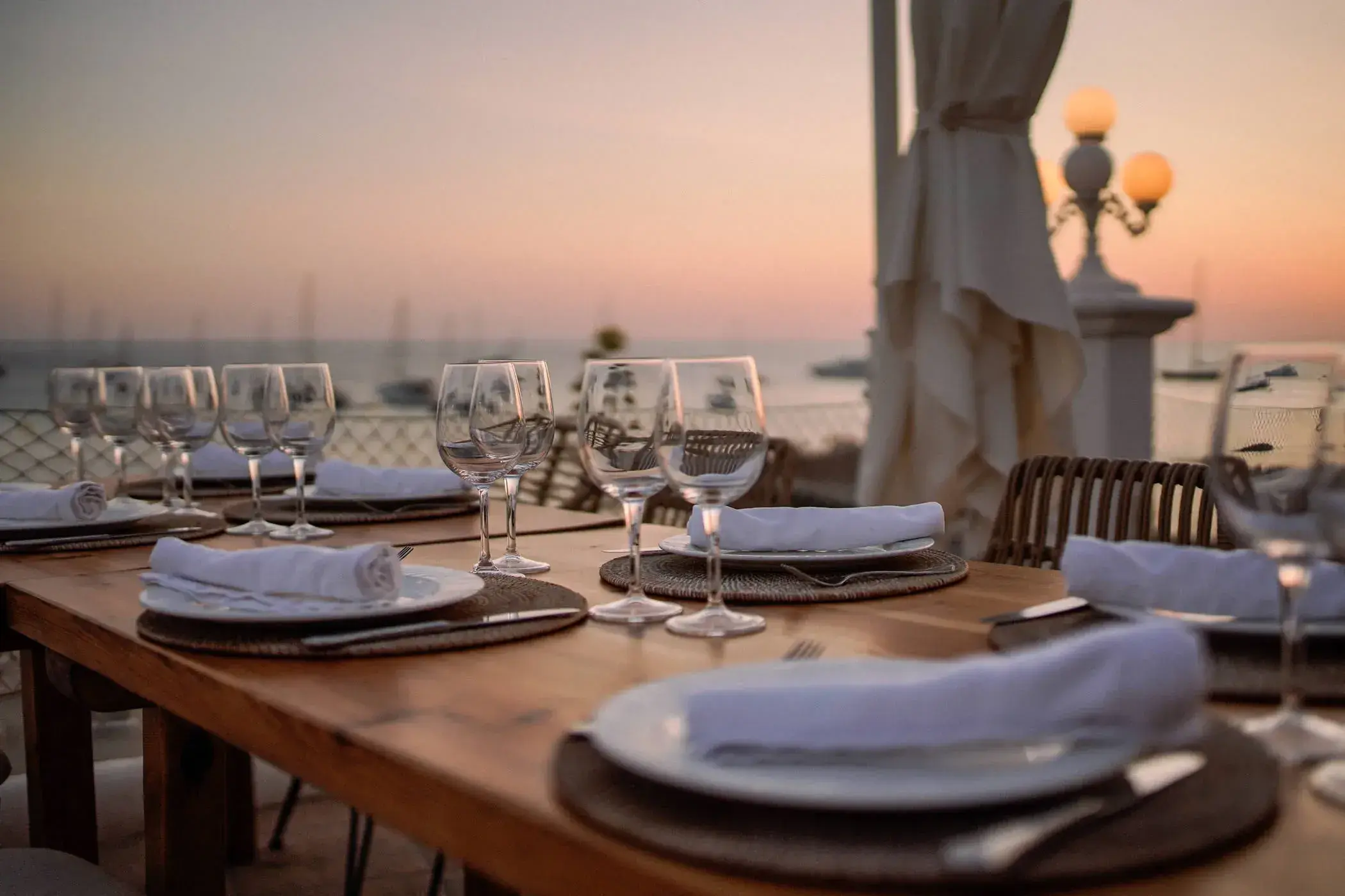 Cas Milà: Tables laid for dinner on the seafront terrace at dusk