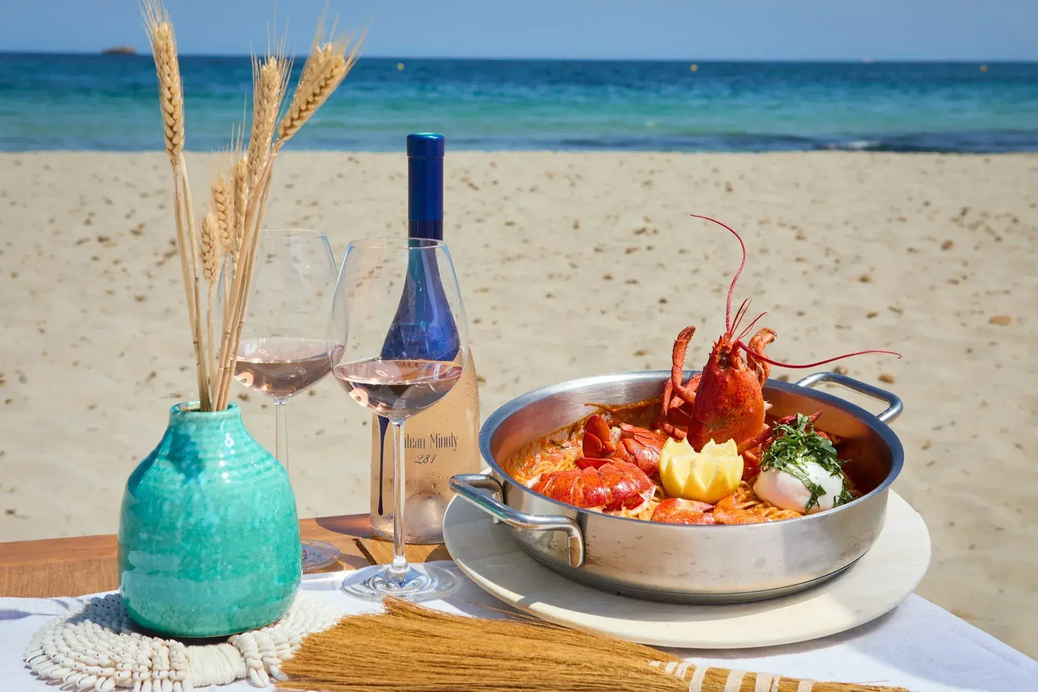 Coco Beach Ibiza: Lobster dish and wine on a table by the sea