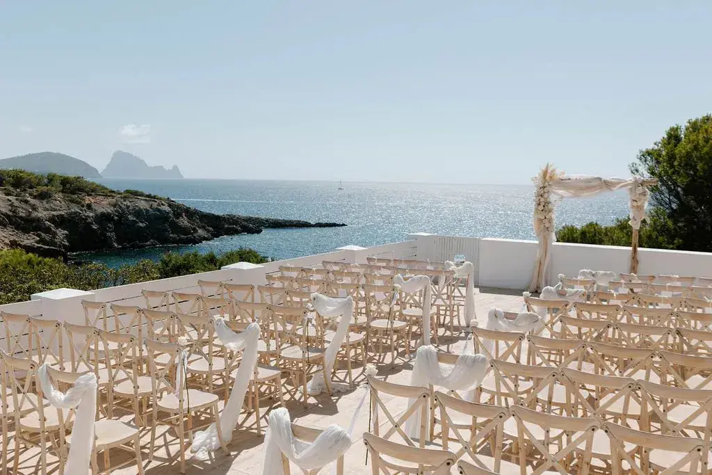 Elixir: Rows of ceremony chairs on the terrace with Es Vedrà behind