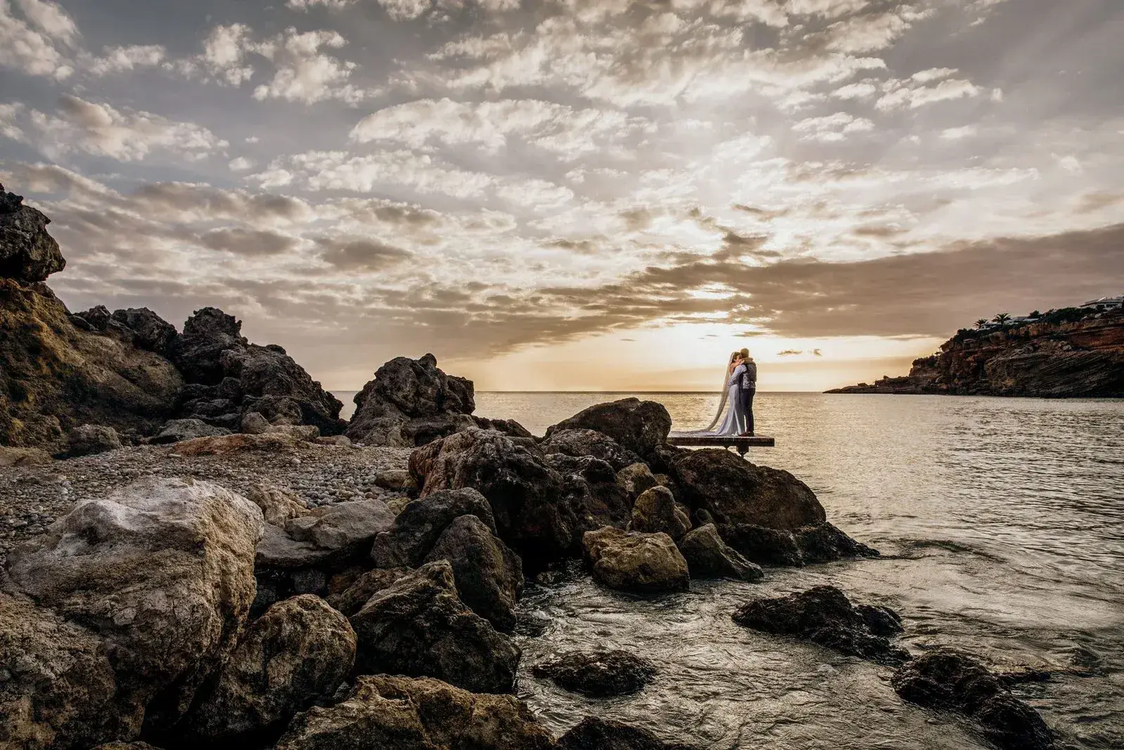 Elixir: Couple on the rocks by the sea at sunset