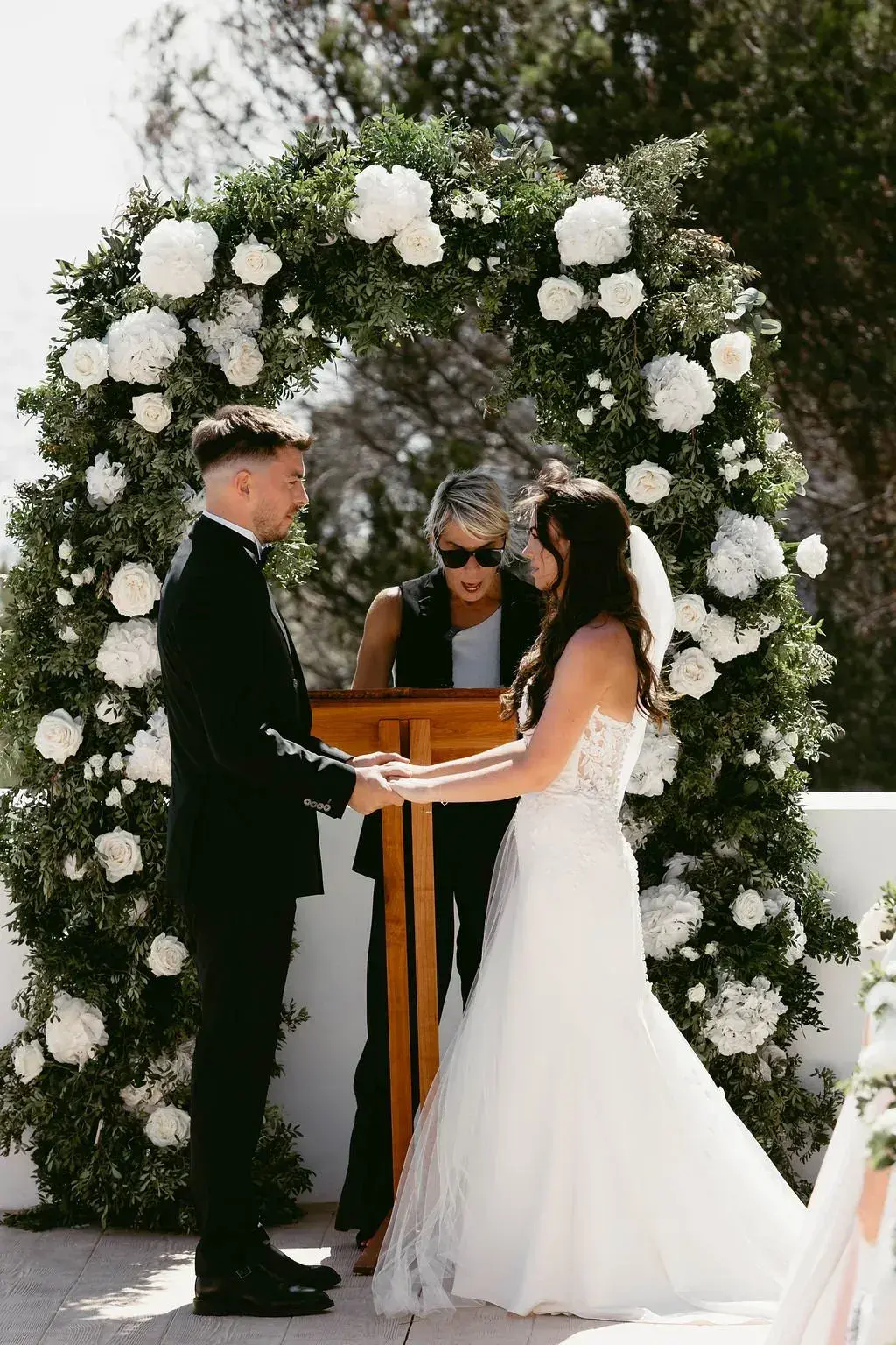 Elixir: Vows under a white flower arch on the terrace
